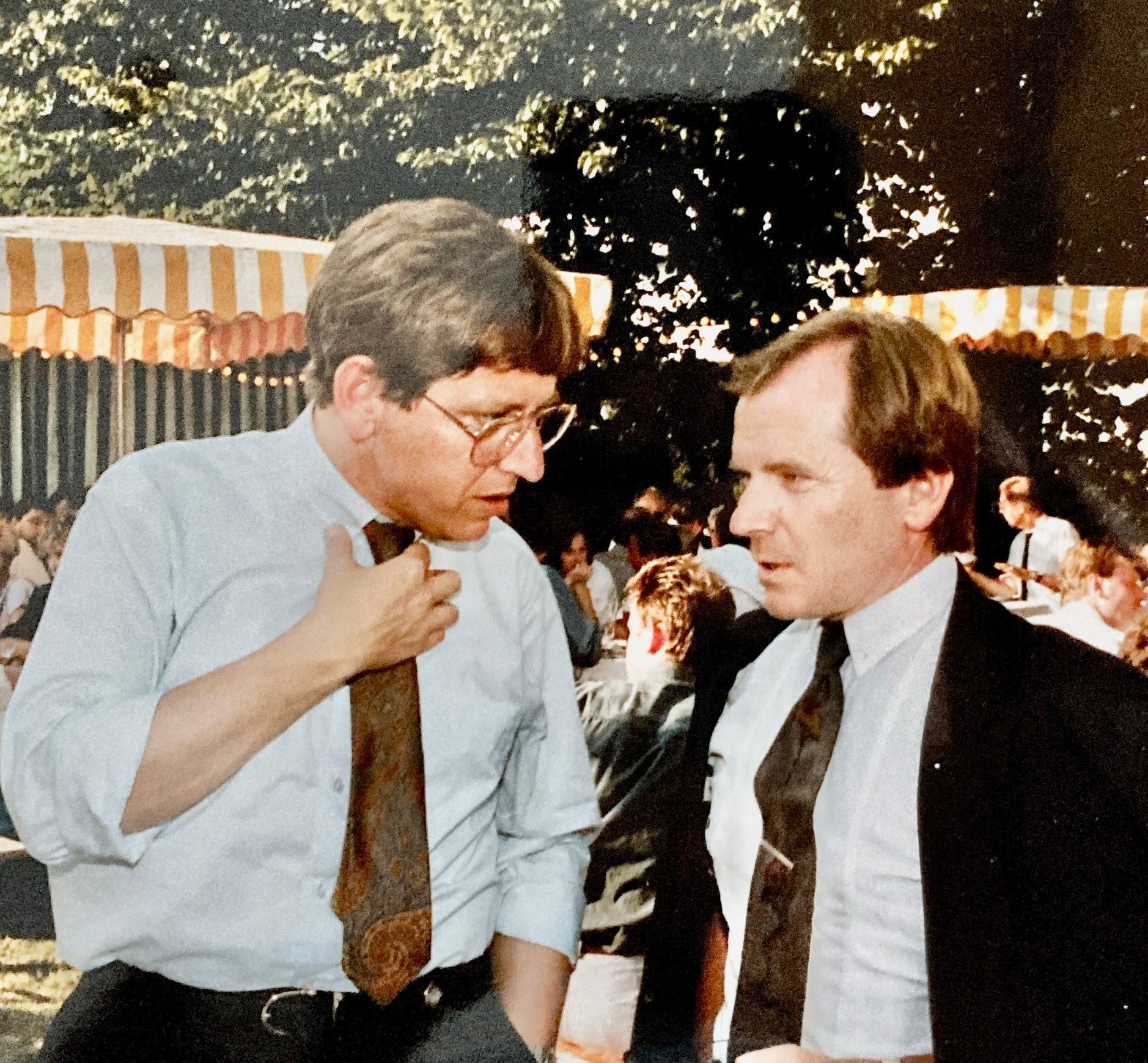 Zwei Männer in Anzug und Krawatte unterhalten sich miteinander