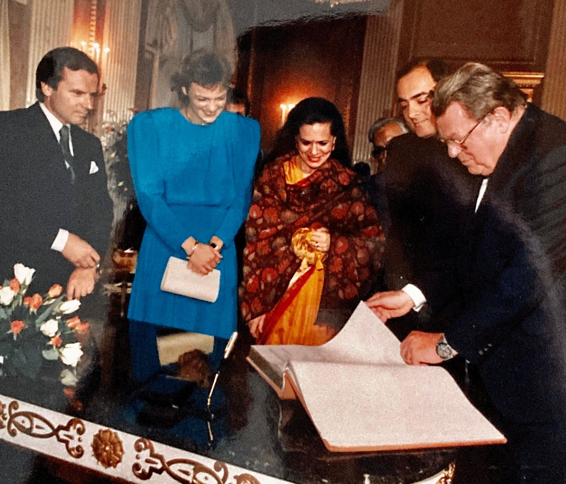 Eine Gruppe von Menschen steht um einen Tisch herum, auf dem ein Schild mit der Aufschrift „a“ steht