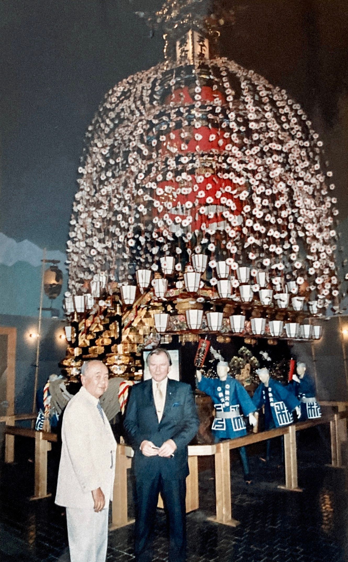 Zwei Männer stehen vor einer großen, mit Blumen bedeckten Kuppel.
