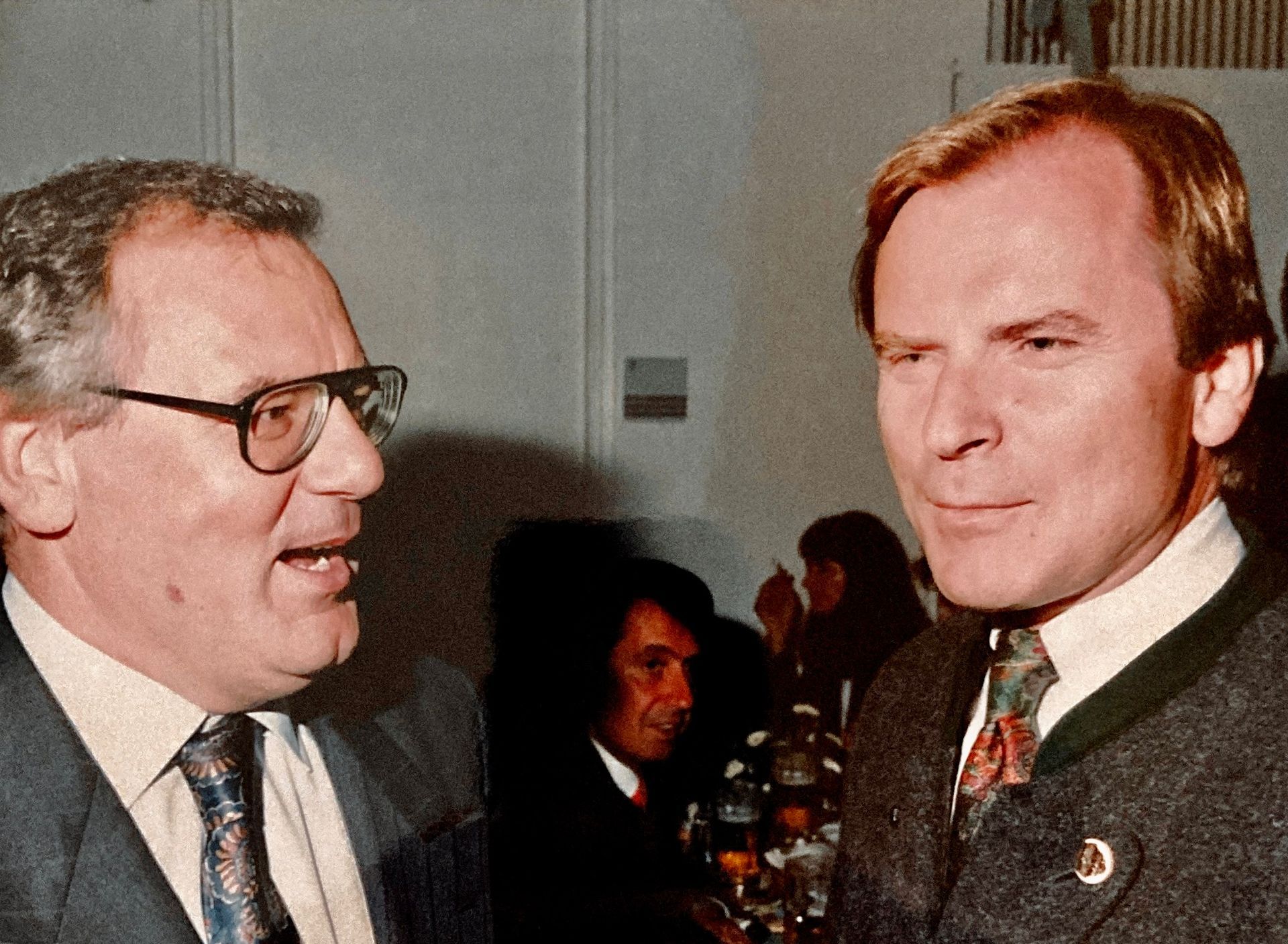 Zwei Männer in Anzug und Krawatte unterhalten sich miteinander