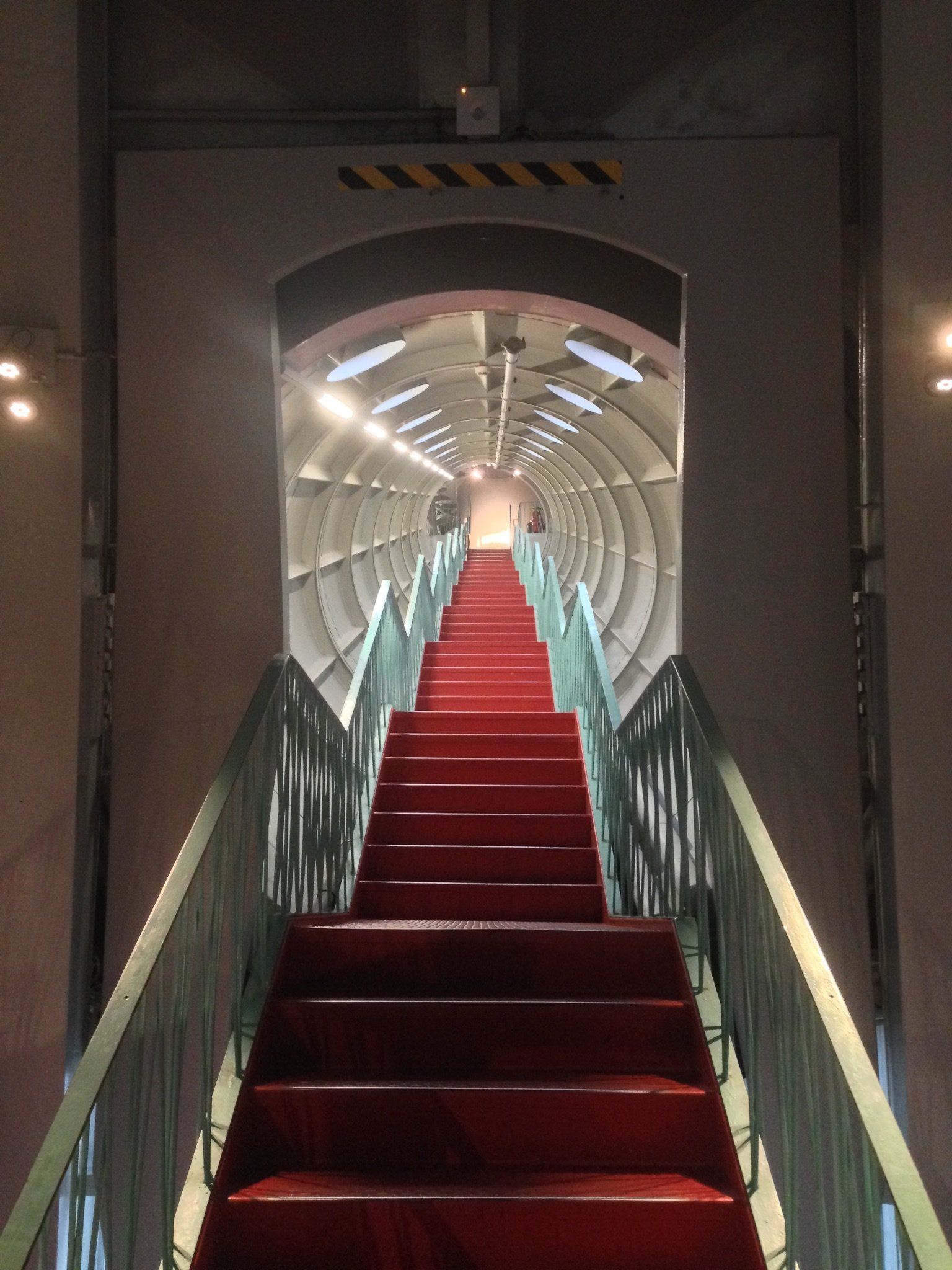 Eine mit rotem Teppich ausgelegte Treppe, die zu einem Tunnel hinaufführt