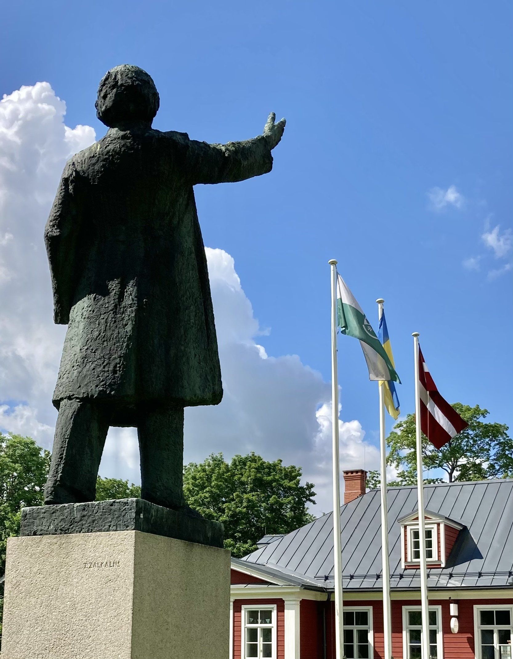 Eine Statue eines Mannes, der vor einem roten Haus steht