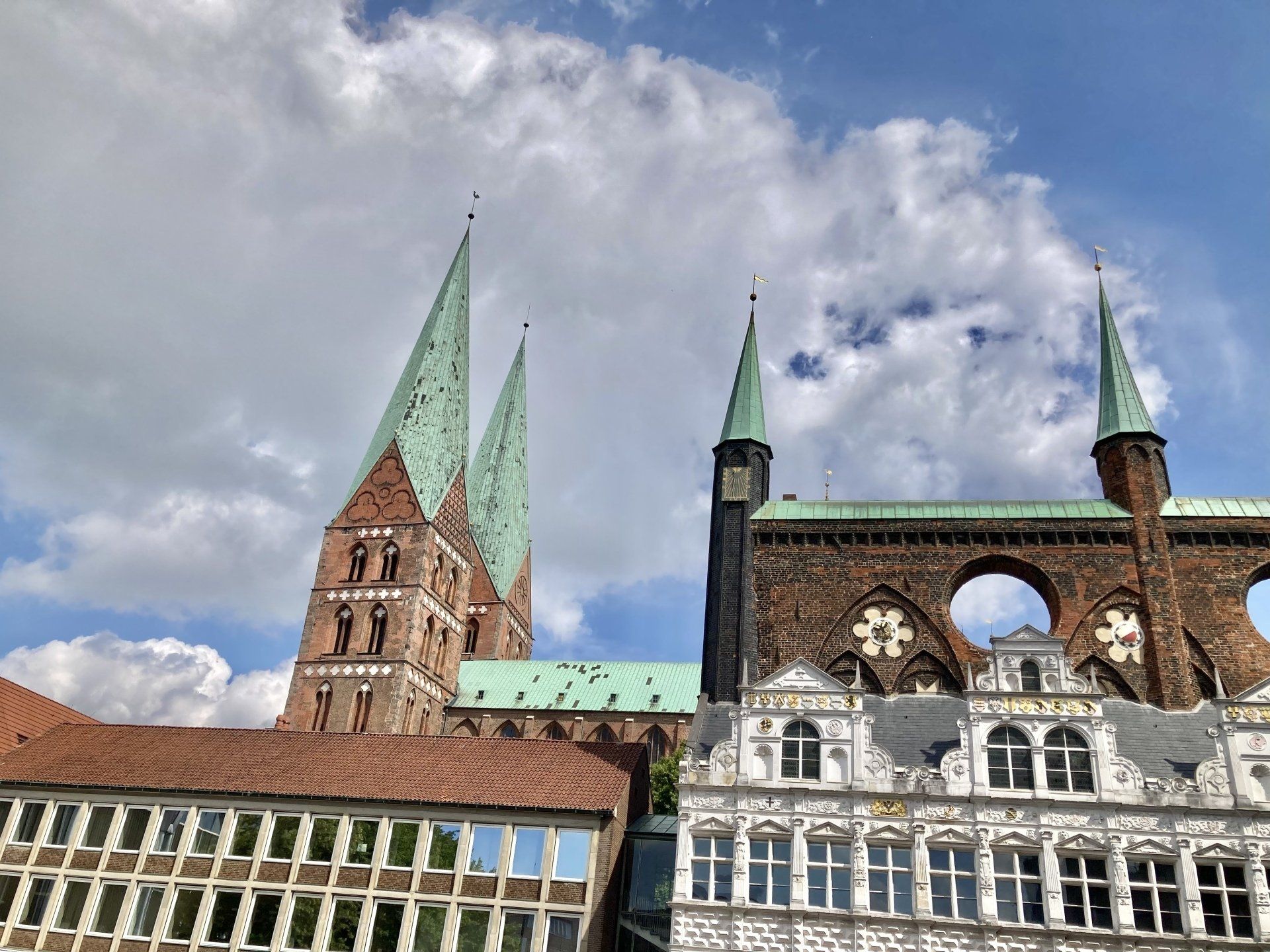 Ein großes Backsteingebäude mit grünem Dach und zwei Türmen