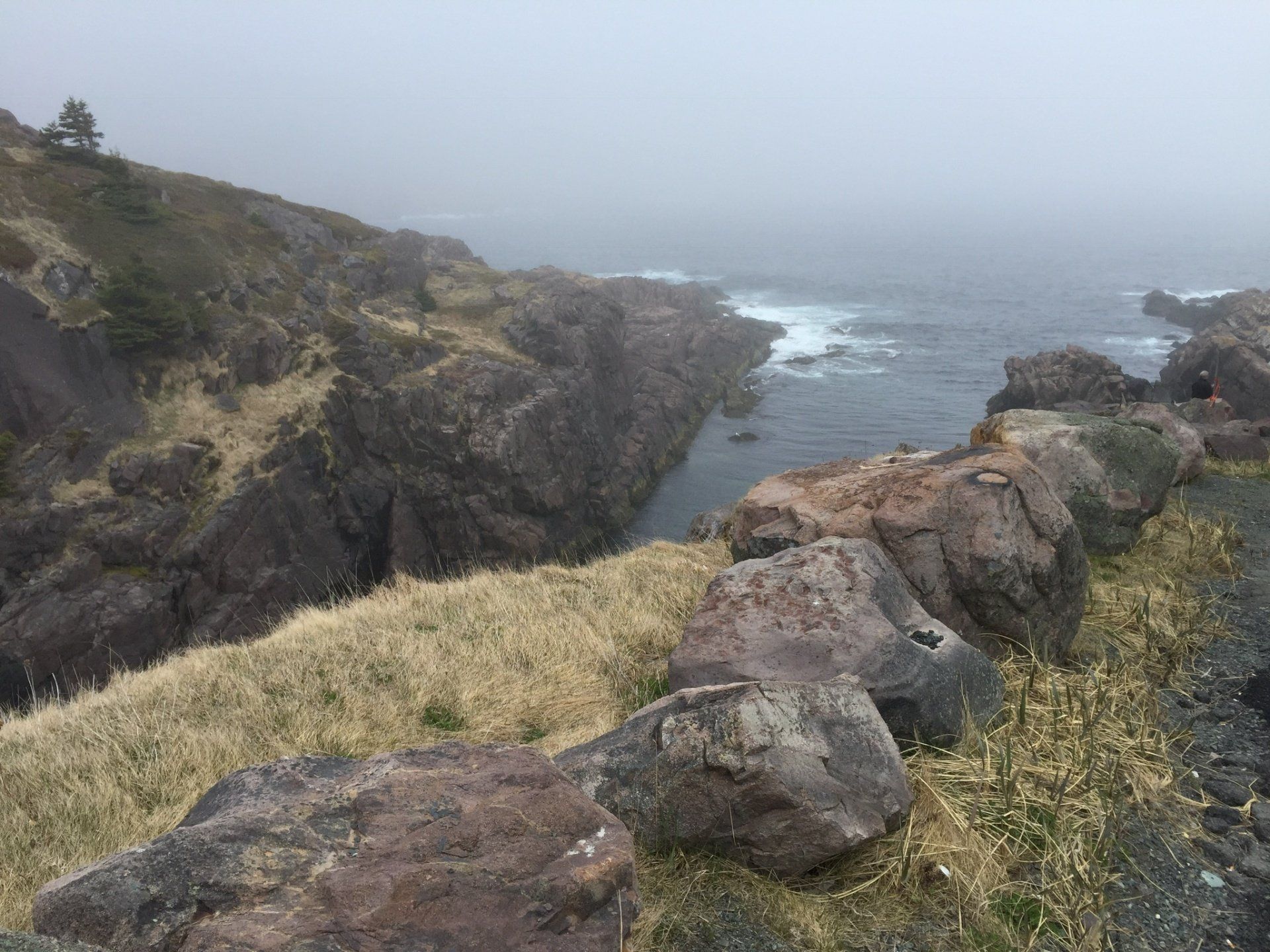 Eine Felsklippe mit Blick auf den Ozean an einem nebligen Tag.