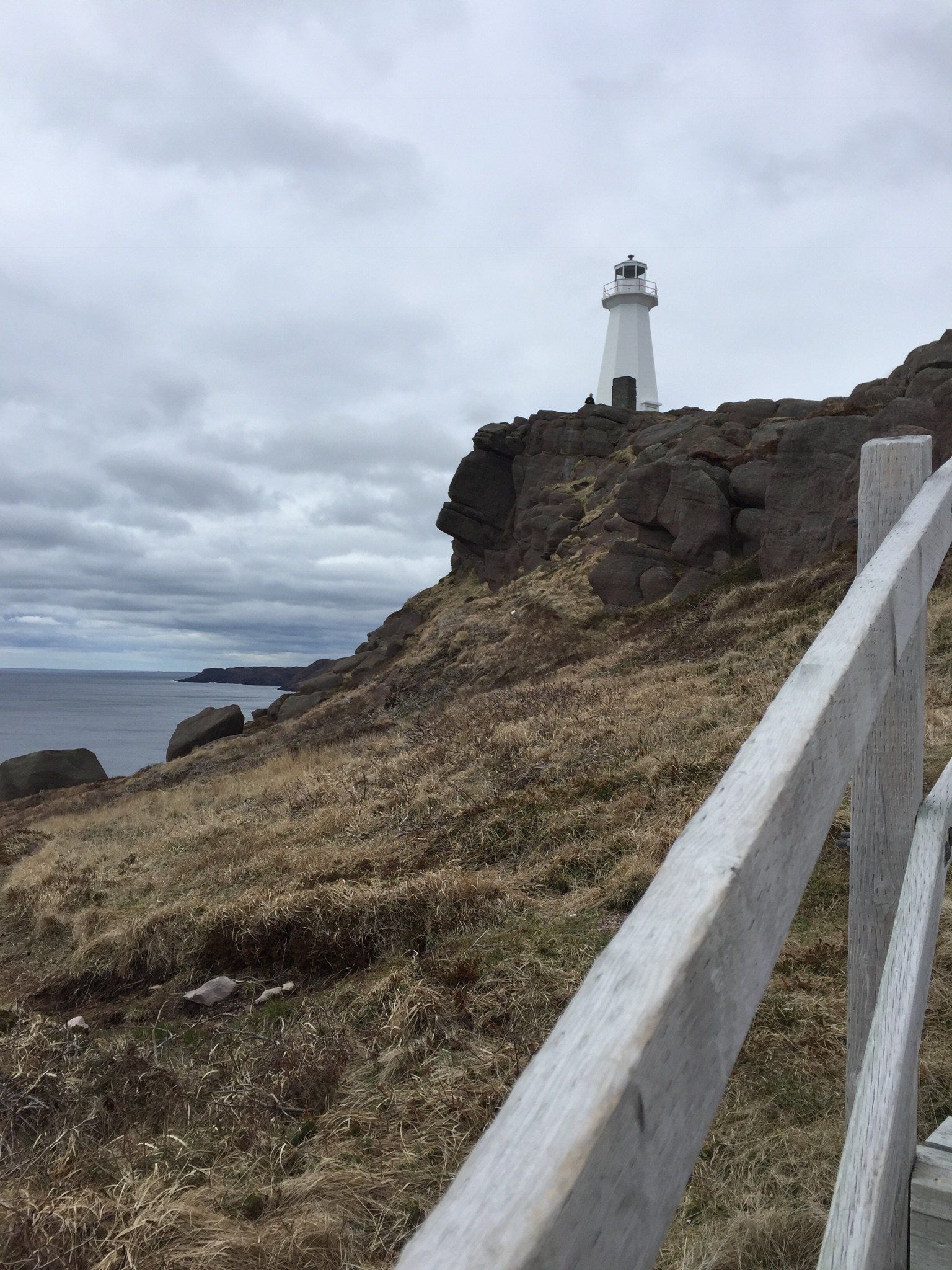 Ein Leuchtturm auf einem Hügel neben dem Meer.