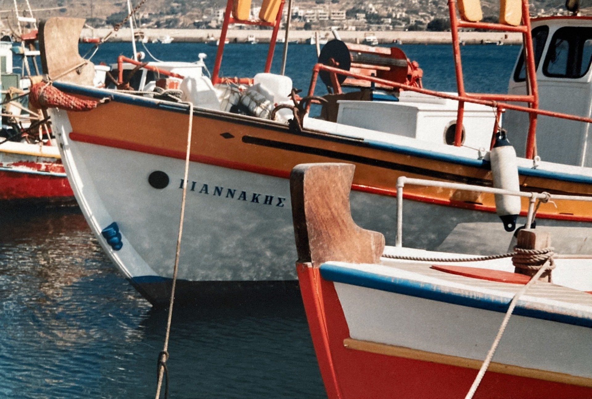 Mehrere Boote liegen in einem Hafen, eines davon heißt ilannaere
