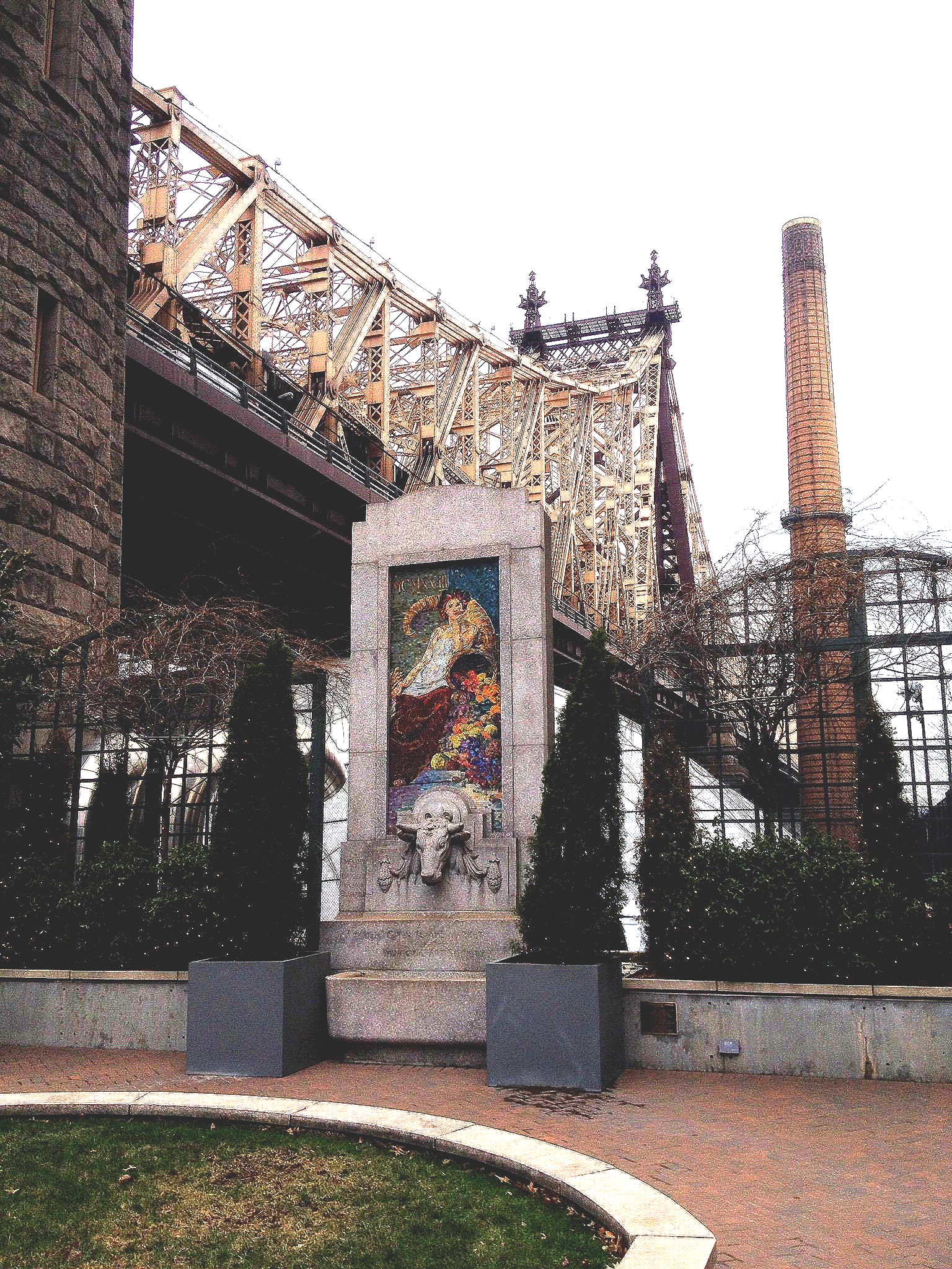 Eine Statue vor einem Gebäude mit einer Brücke im Hintergrund
