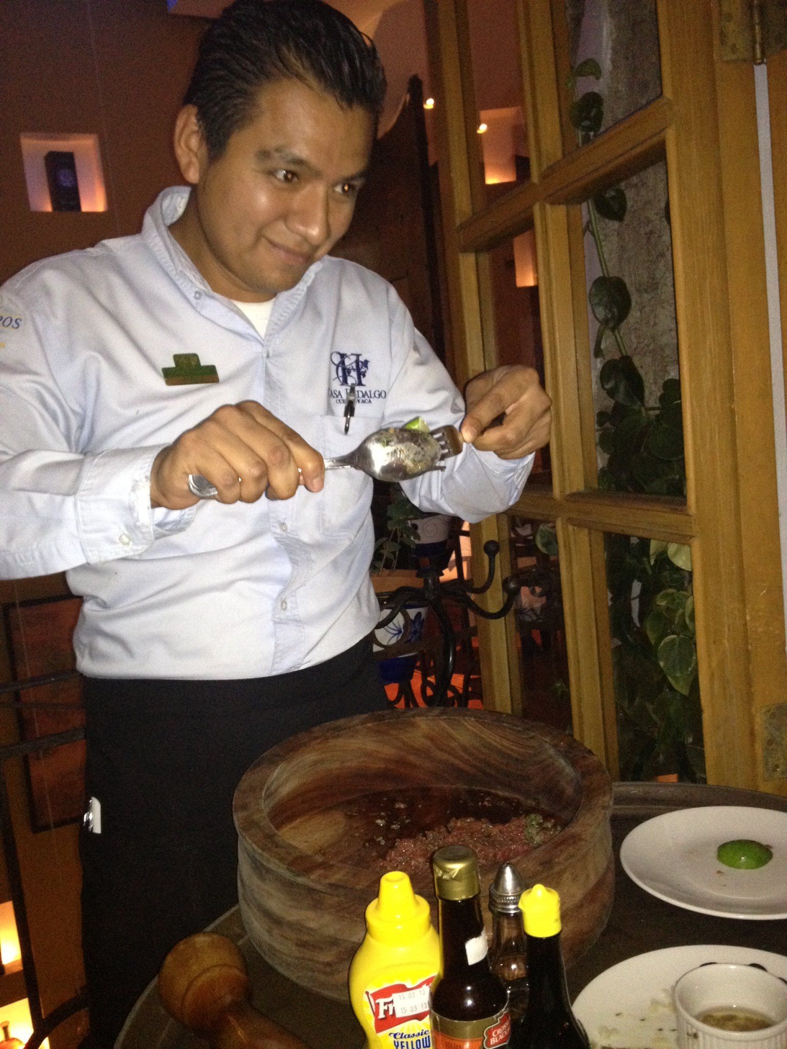 Ein Mann in einem weißen Hemd schneidet ein Stück Essen