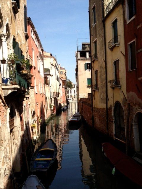 Ein schmaler Kanal zwischen zwei Gebäuden mit Booten darin