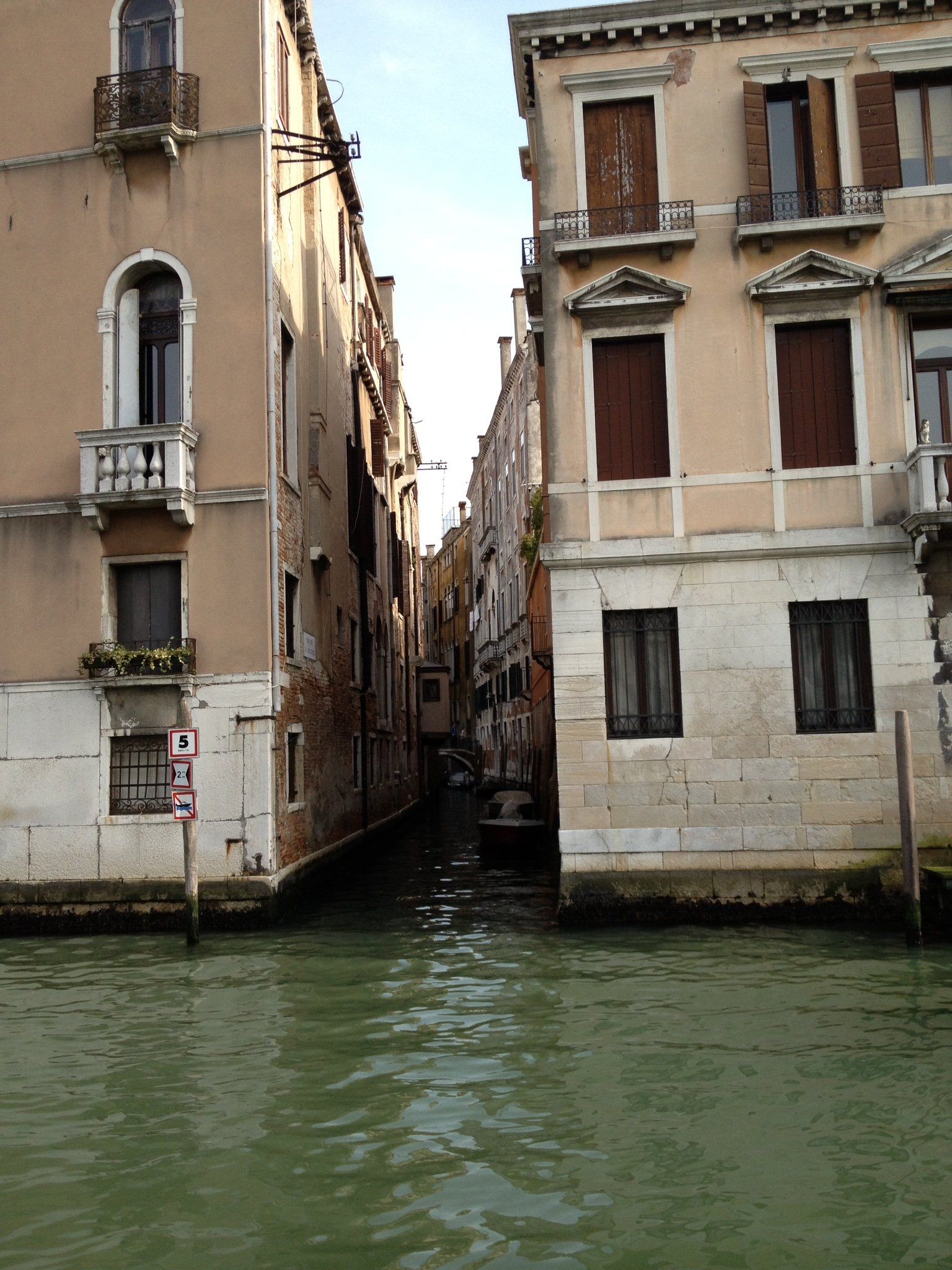 Eine schmale Gasse zwischen zwei Gebäuden neben einem Gewässer