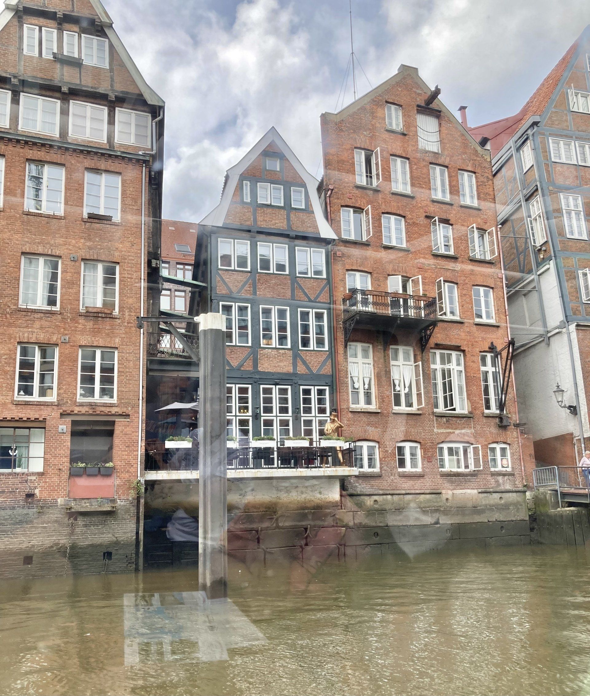 Eine Gruppe von Backsteingebäuden neben einem Gewässer.