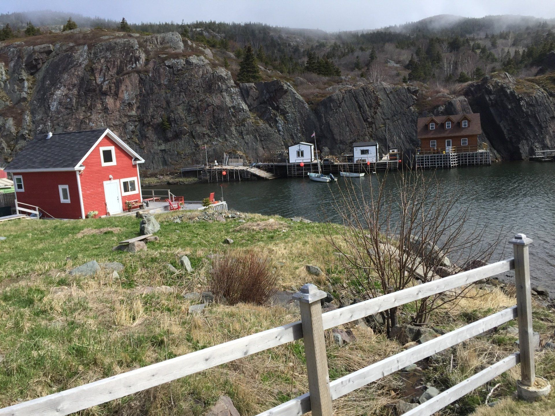Ein kleines rotes Haus steht neben einem Gewässer.