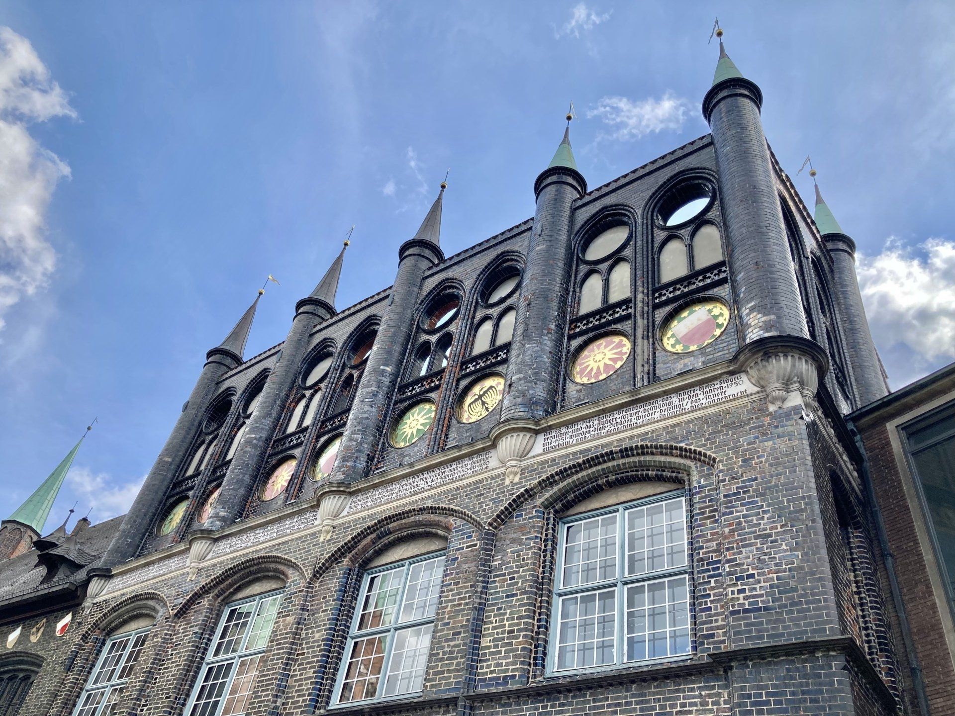 Ein großes Backsteingebäude mit vielen Fenstern und Uhren.