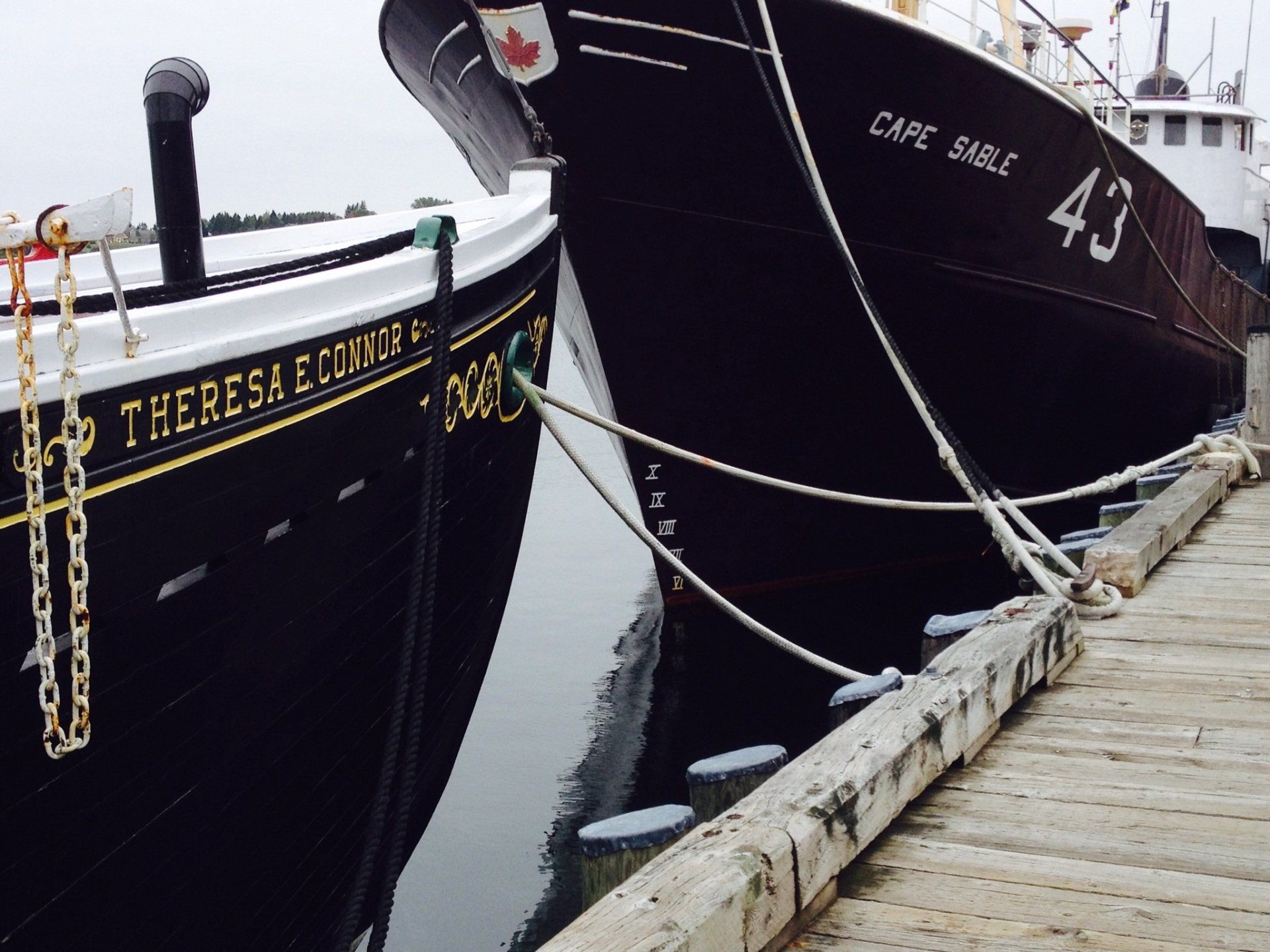 Zwei Boote sind an einem Dock festgemacht und eines trägt den Namen Theresa an der Seite