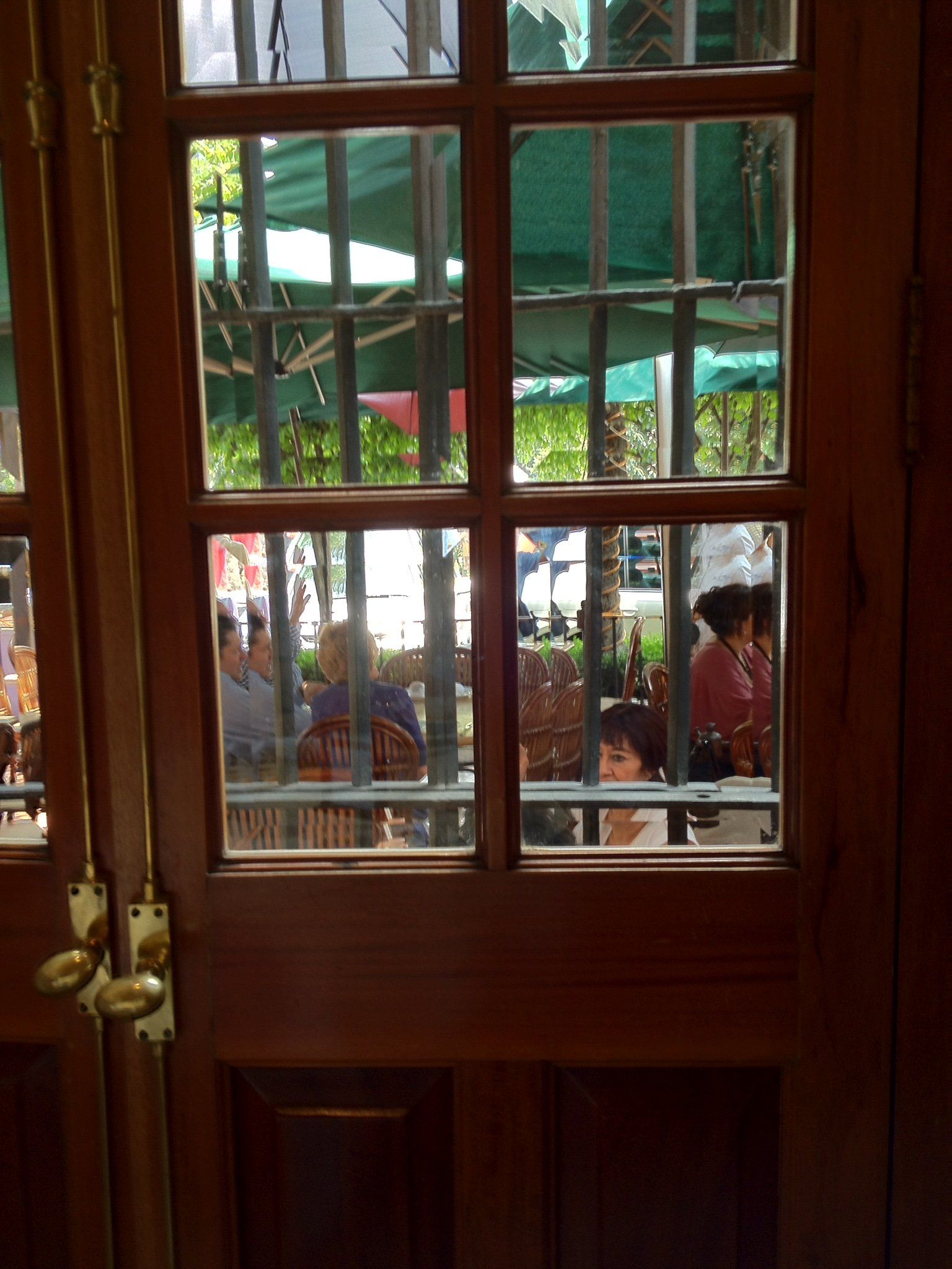 Eine Holztür mit der Spiegelung von Menschen darin