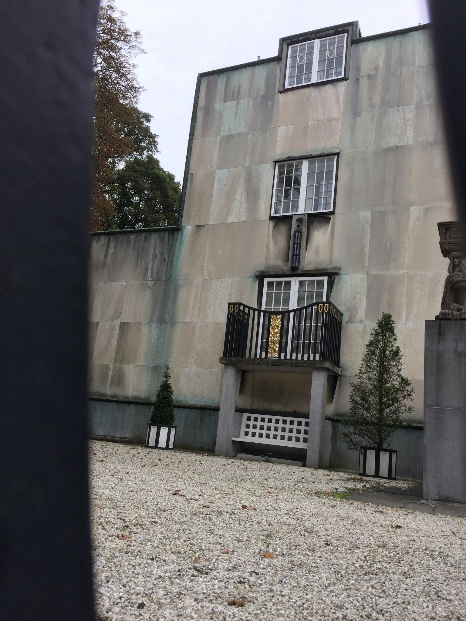 Ein Gebäude mit einem Balkon und einer Bank davor