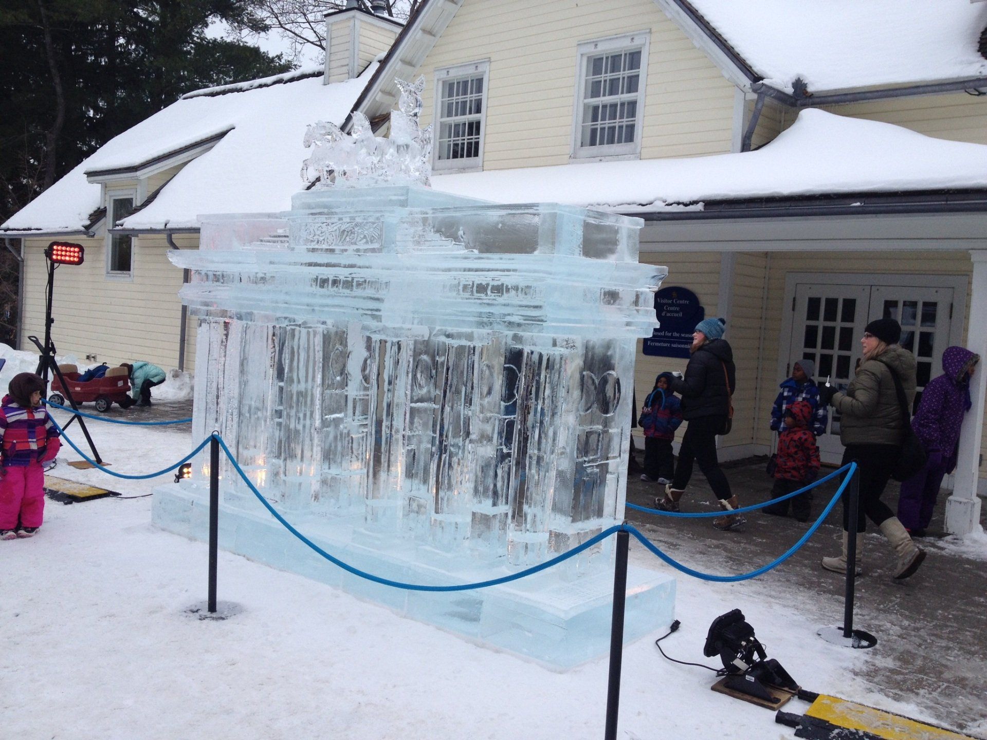 Eine große Eisskulptur vor einem schneebedeckten Haus