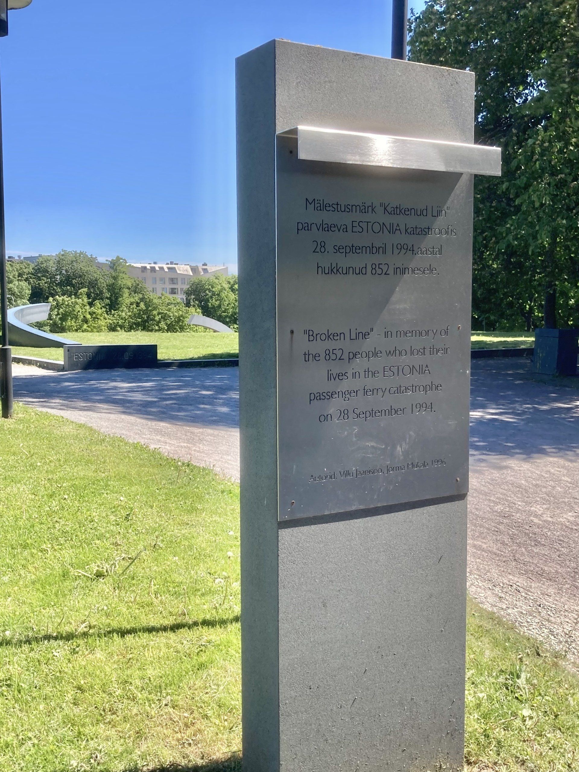 Eine Steinsäule mit einer Gedenktafel in einem Park