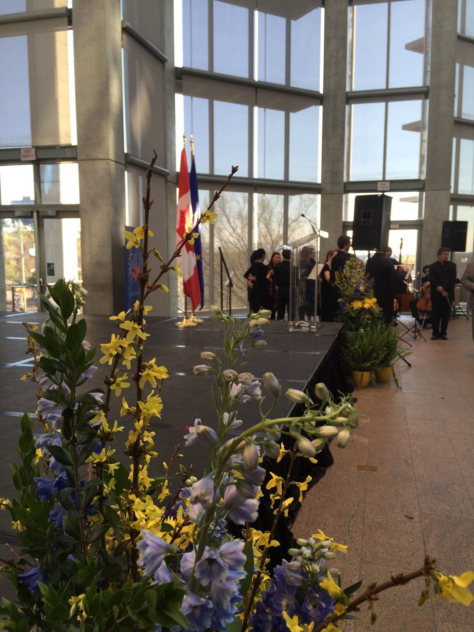 Eine Gruppe von Menschen steht vor einer Bühne mit Blumen im Vordergrund