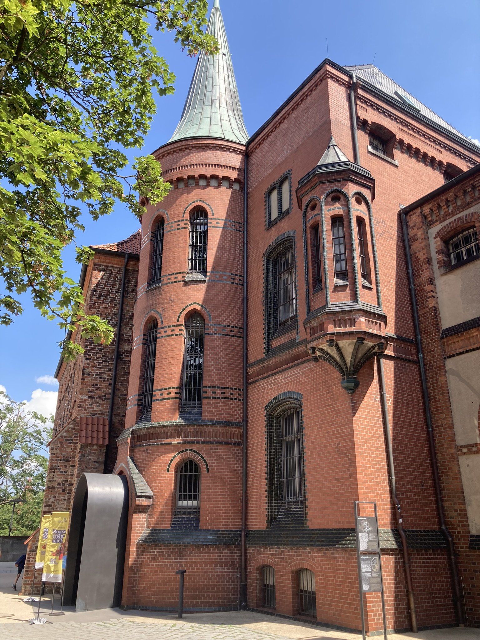 Ein großes rotes Backsteingebäude mit einem Turm darauf.