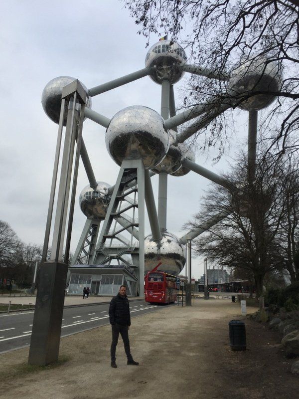 Ein Mann steht vor einem großen Riesenrad.