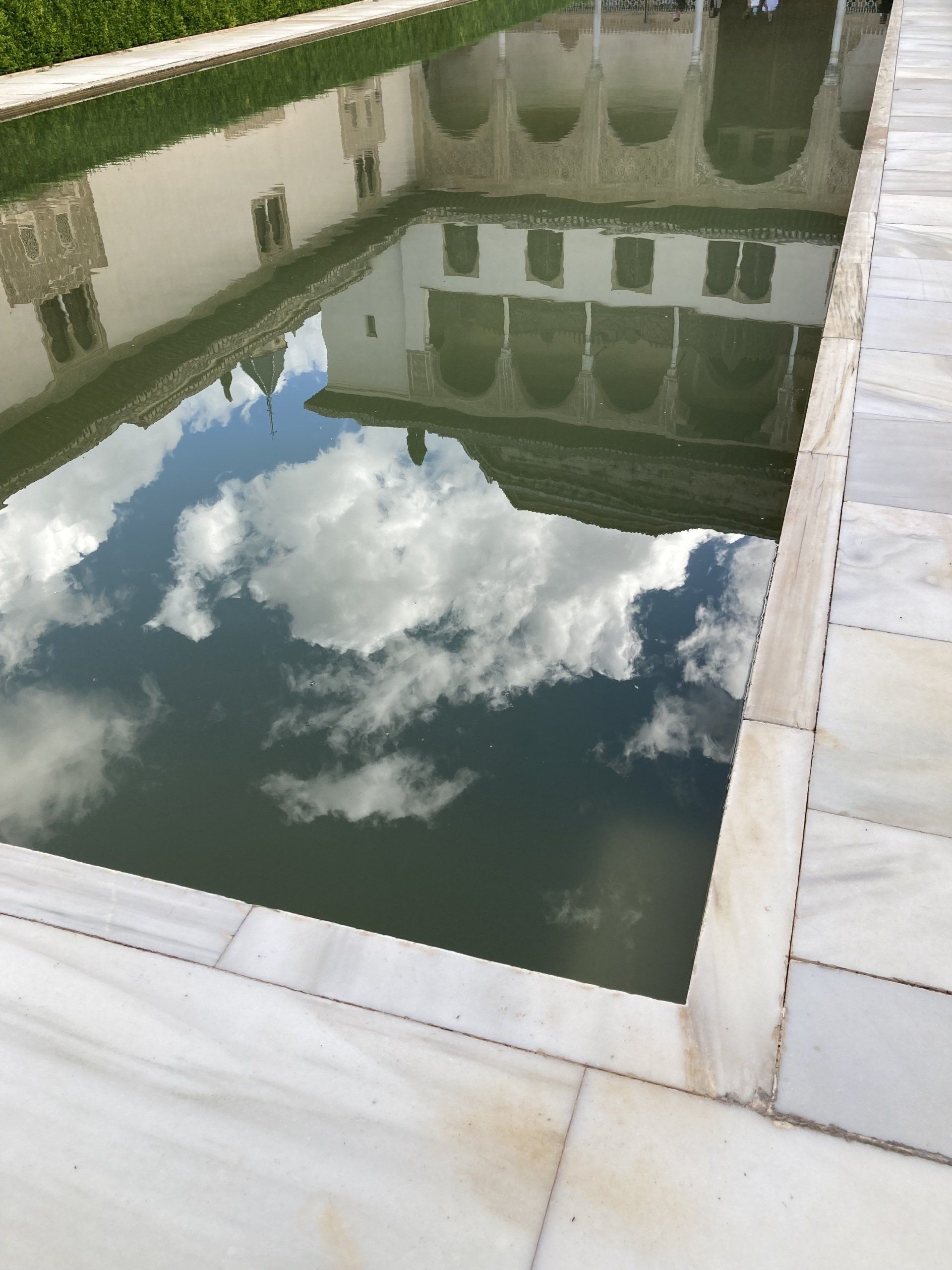 Ein Swimmingpool mit einem Gebäude, das sich im Wasser spiegelt