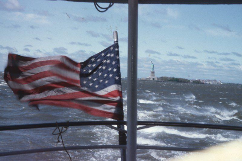 Die Freiheitsstatue ist durch das Fenster eines Bootes sichtbar