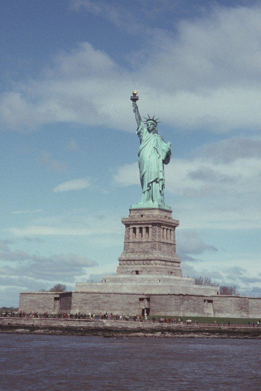 Die Freiheitsstatue steht inmitten eines Gewässers.