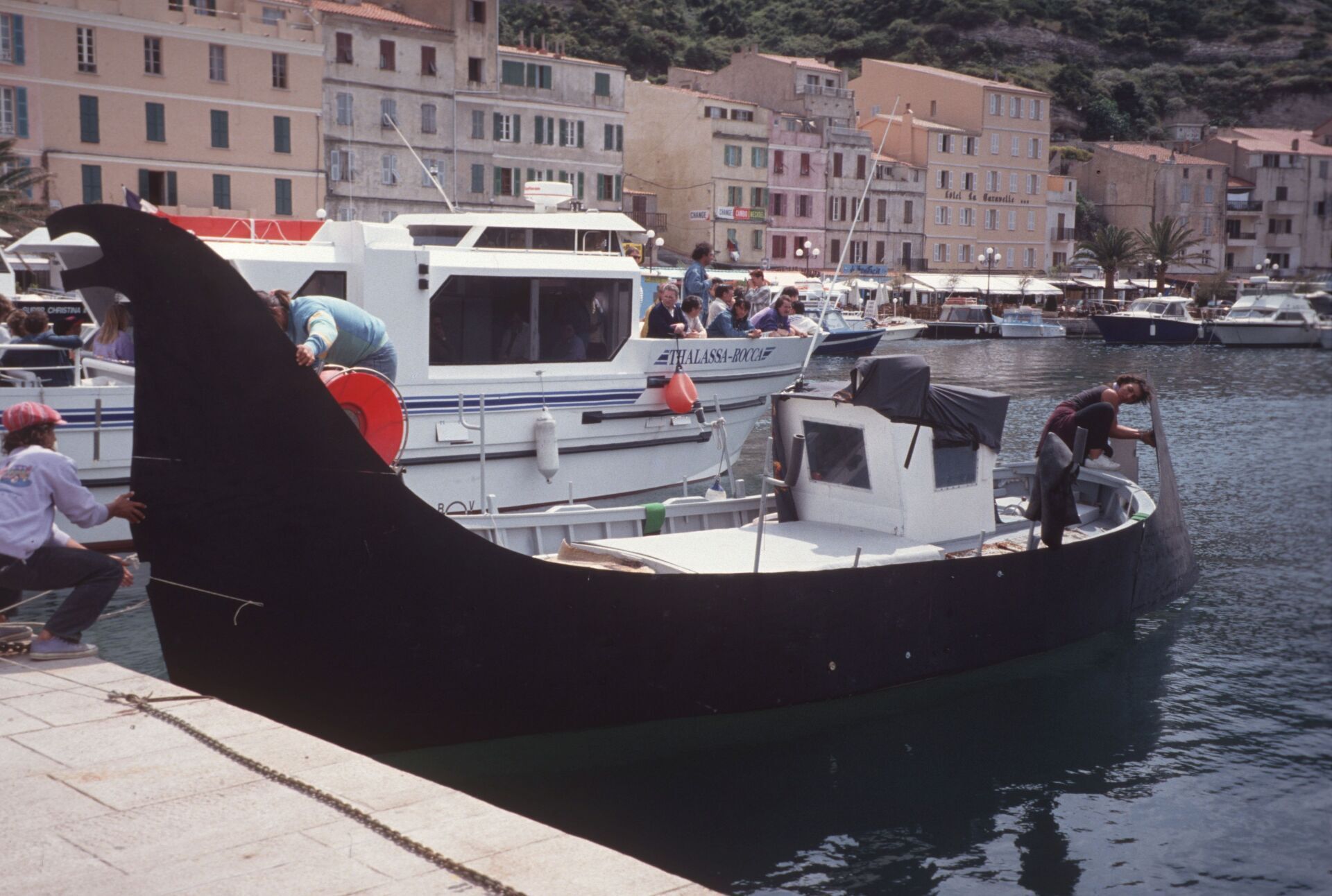 Ein Boot mit einem großen Heck liegt in einem Hafen