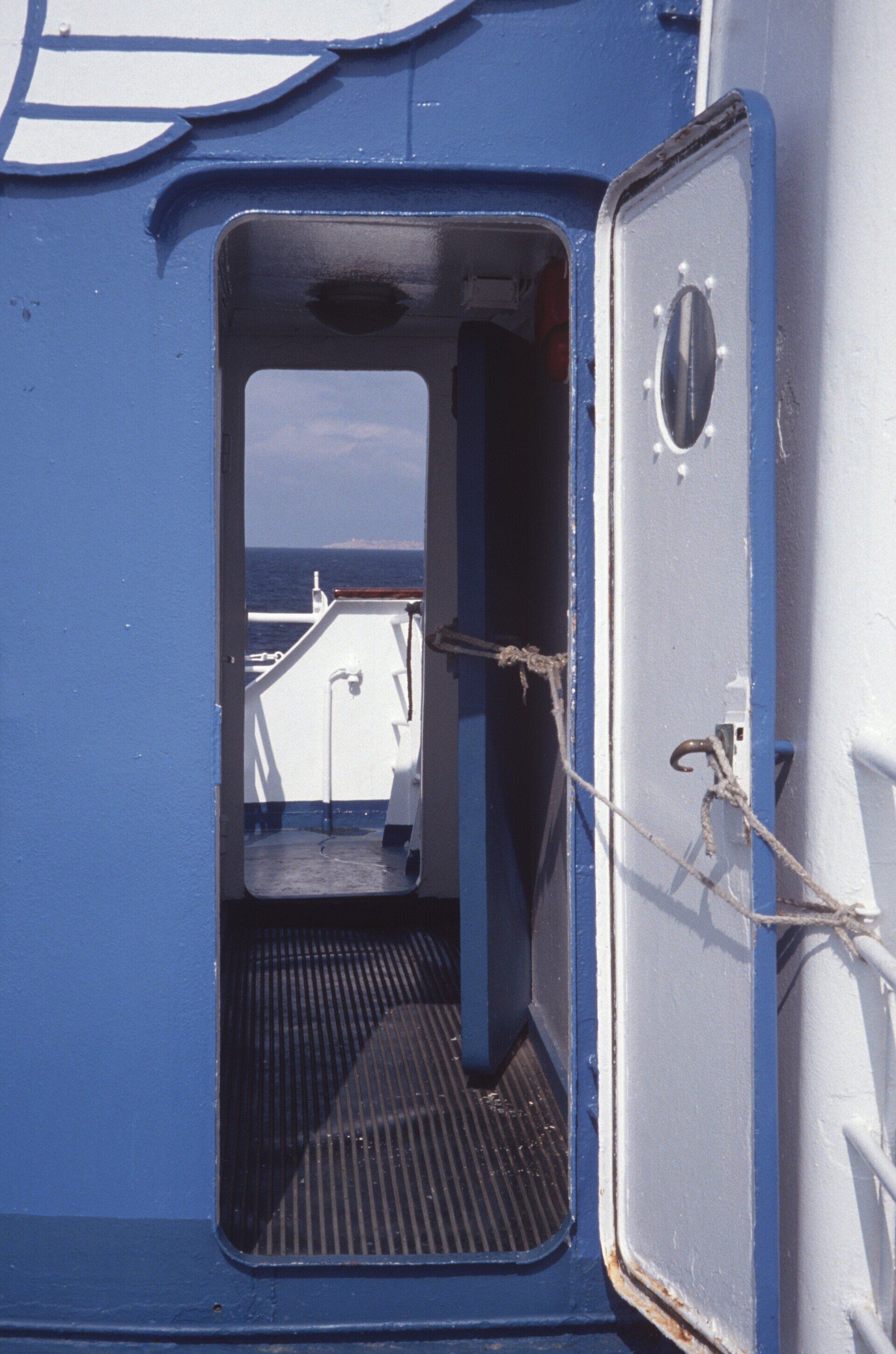 Eine blaue Tür öffnet sich zu einem Raum mit Blick auf das Meer