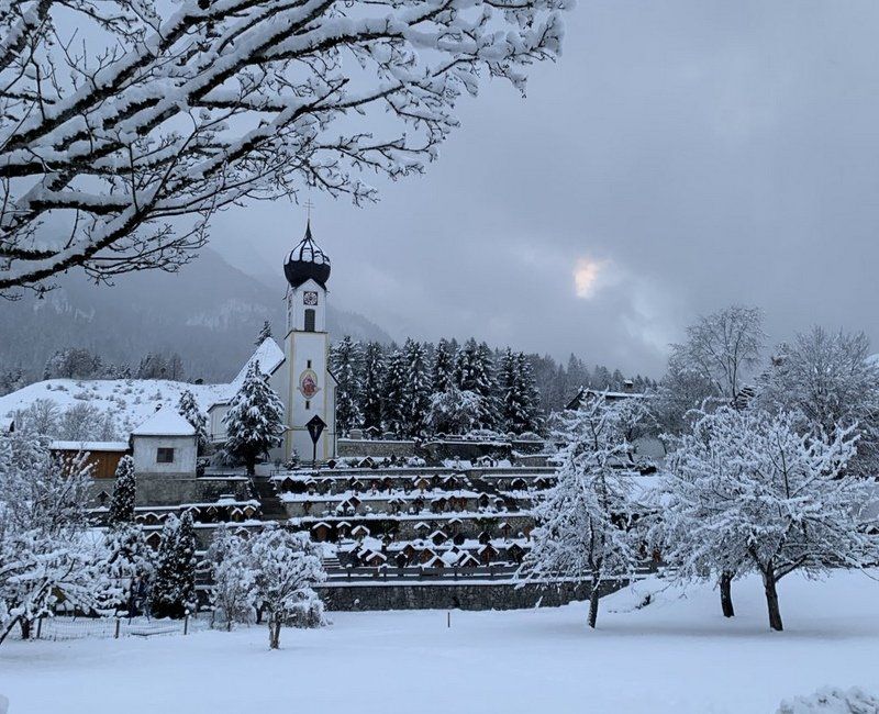 Eine verschneite Landschaft mit einer Kirche im Hintergrund