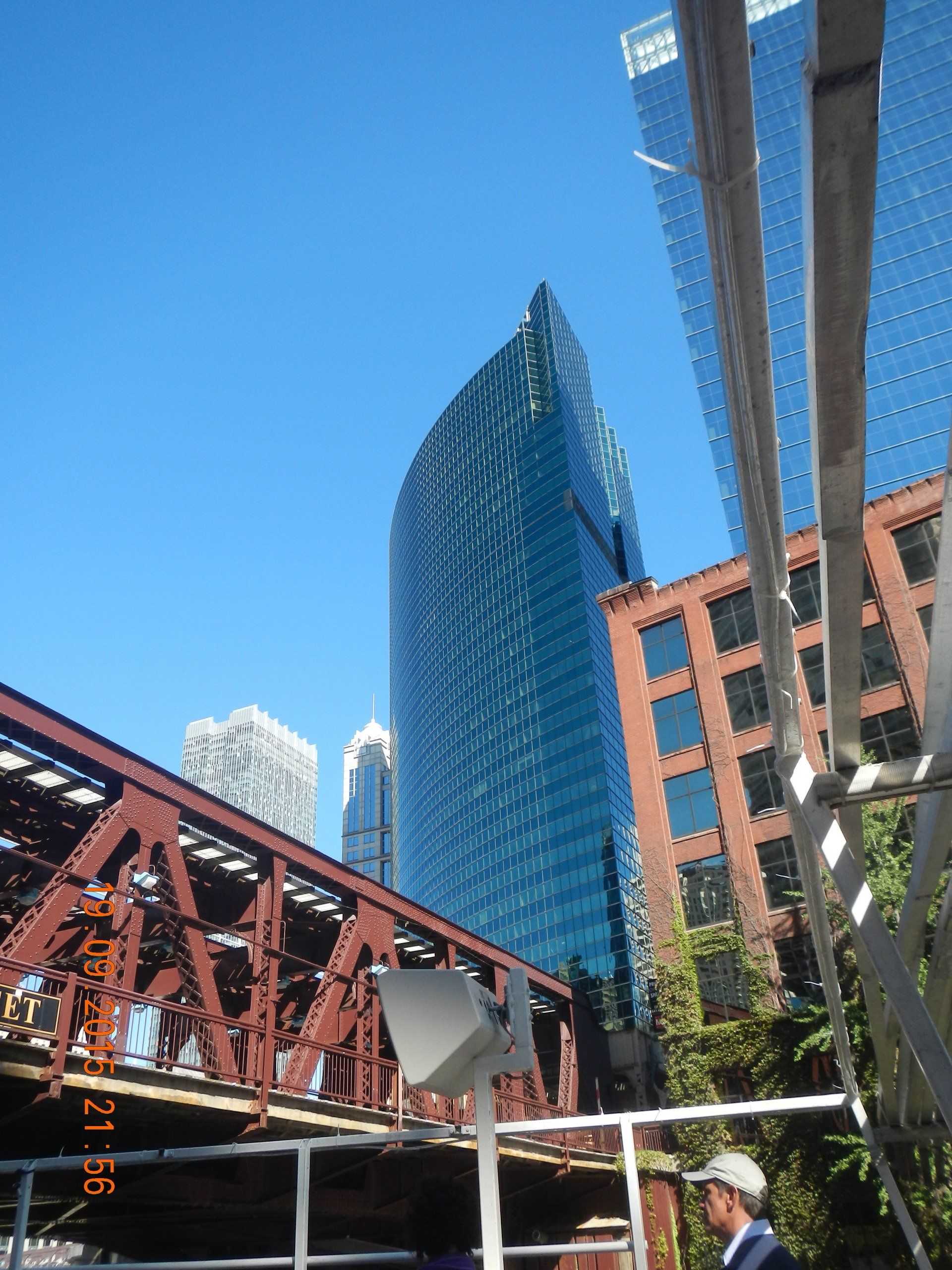 Ein Mann steht auf einer Brücke und blickt auf ein hohes Gebäude