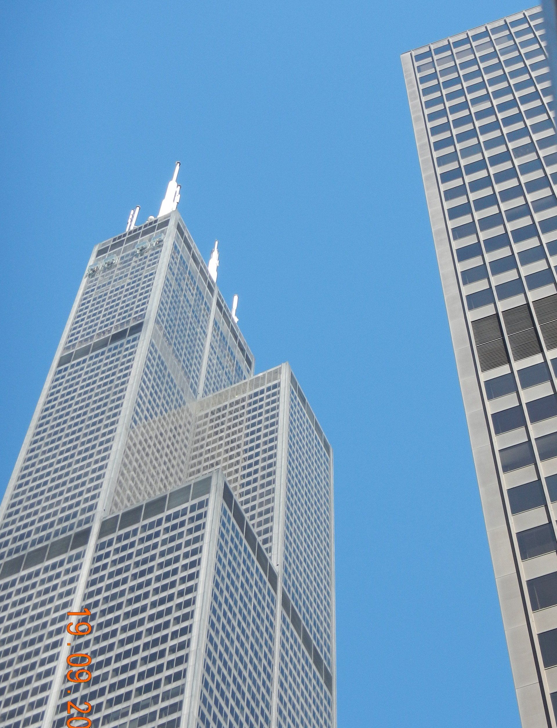 Blick nach oben auf ein hohes Gebäude mit blauem Himmel im Hintergrund