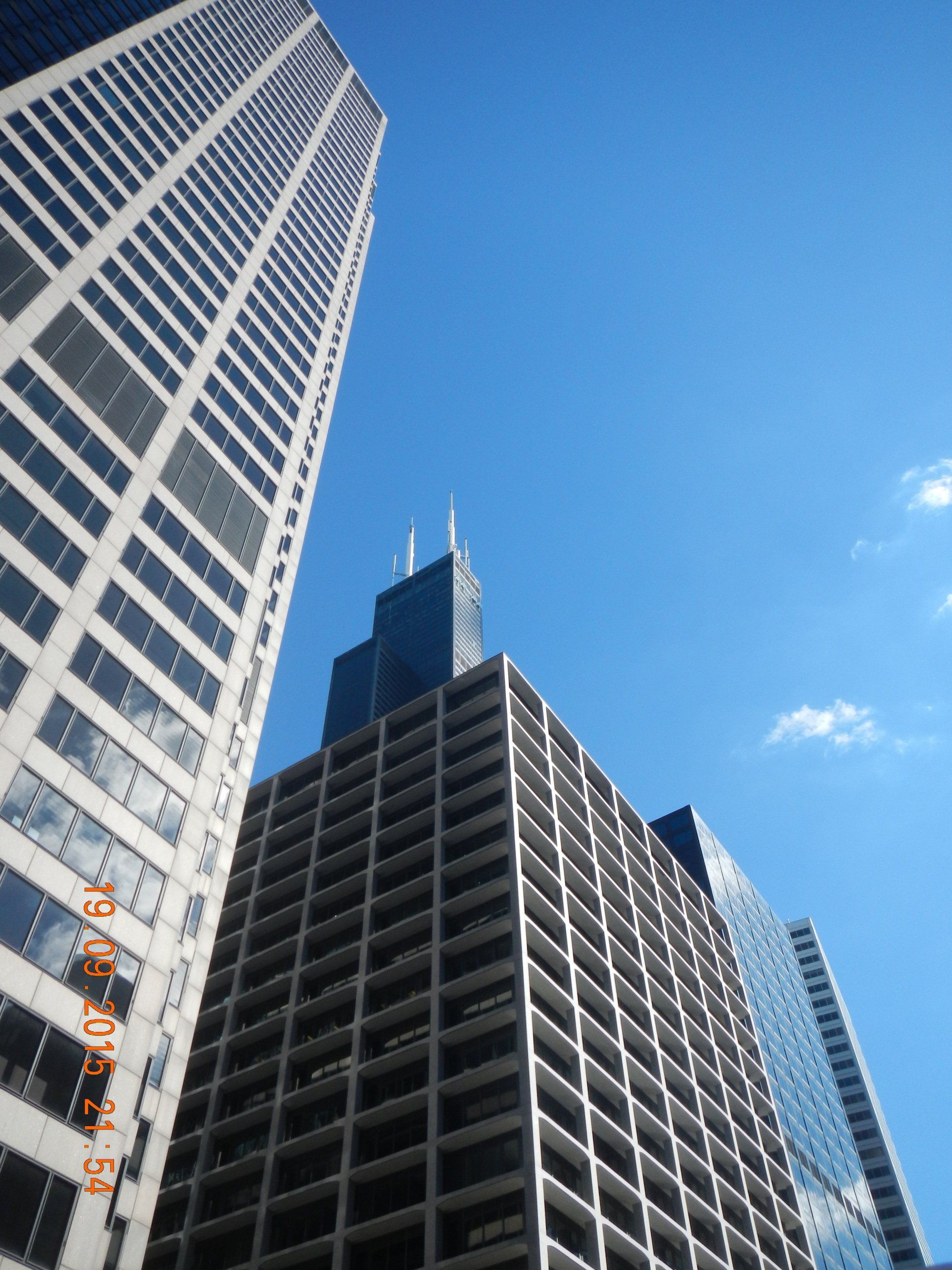 Blick nach oben auf einen Wolkenkratzer mit blauem Himmel im Hintergrund