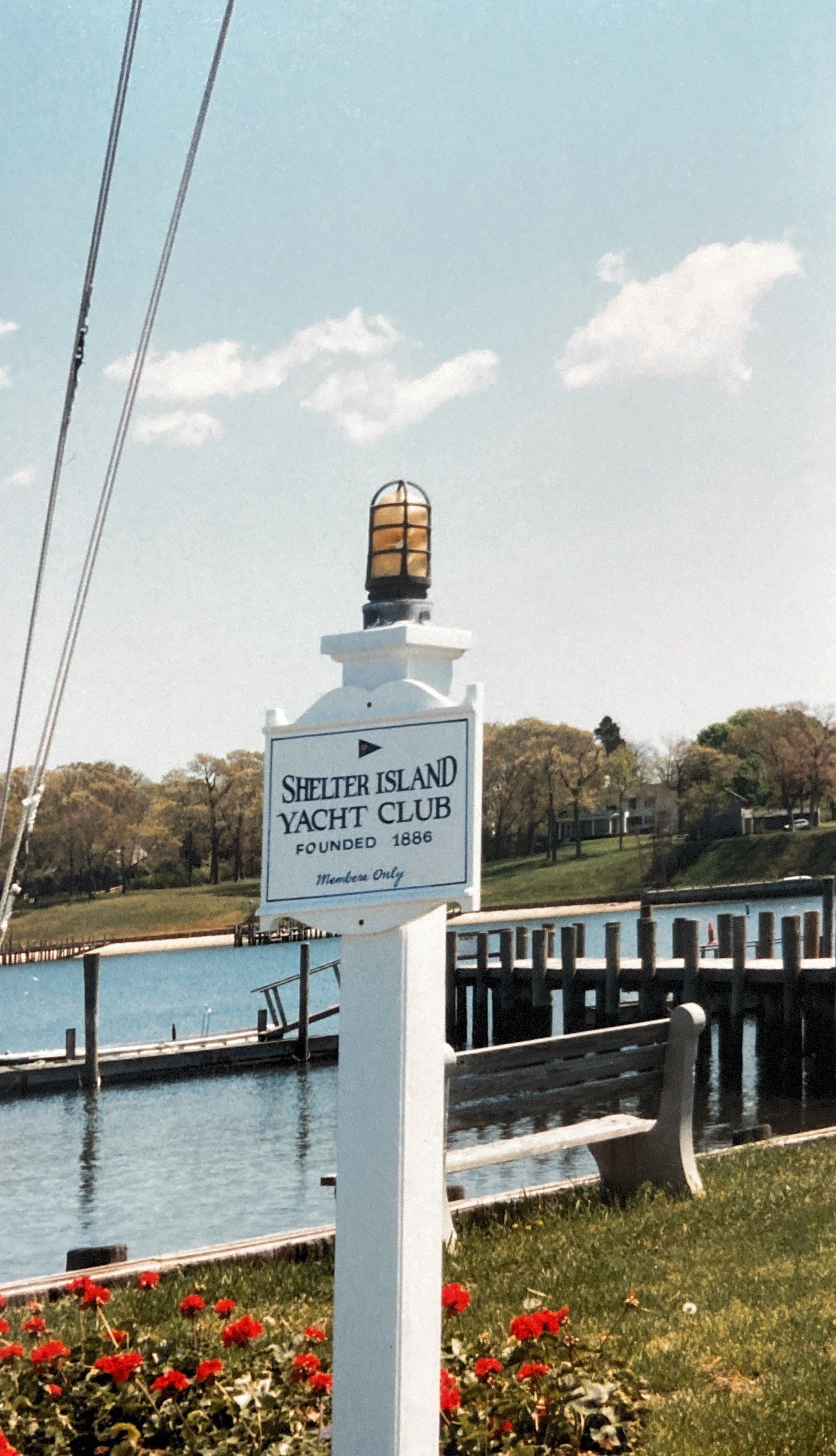 Ein weißer Pfahl mit einem Schild darauf, auf dem steht: Stelzenstrand-Yachtclub