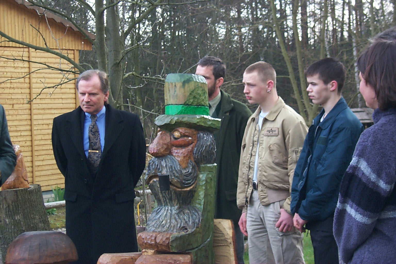 Eine Gruppe von Menschen steht um eine Koboldstatue herum