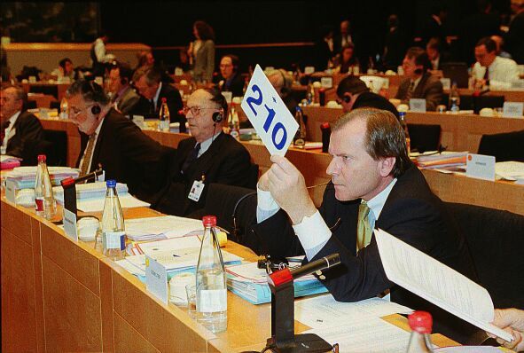 Ein Mann hält ein Schild mit der Nummer 210 hoch