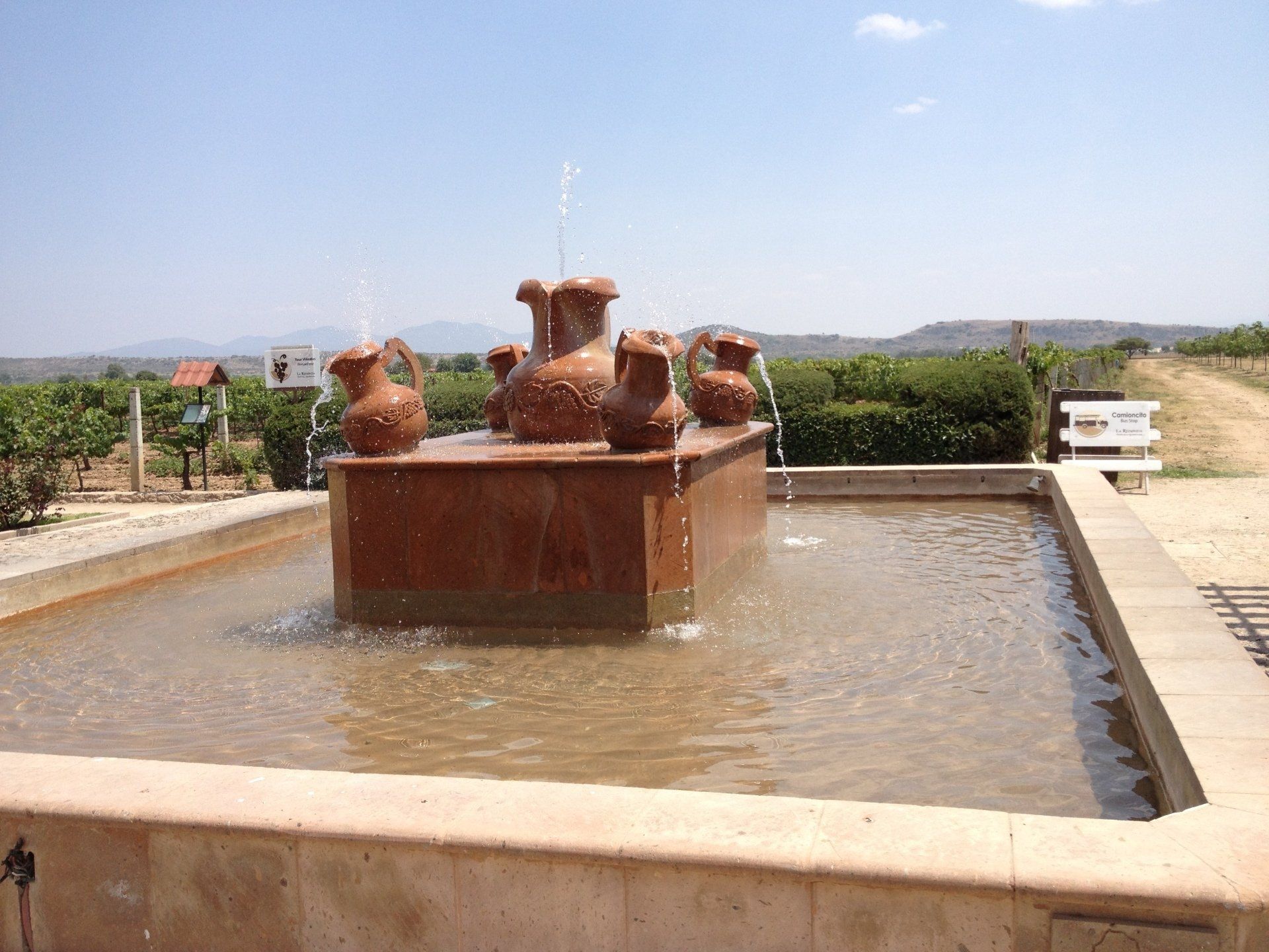 Ein Brunnen mit vielen Krügen darauf