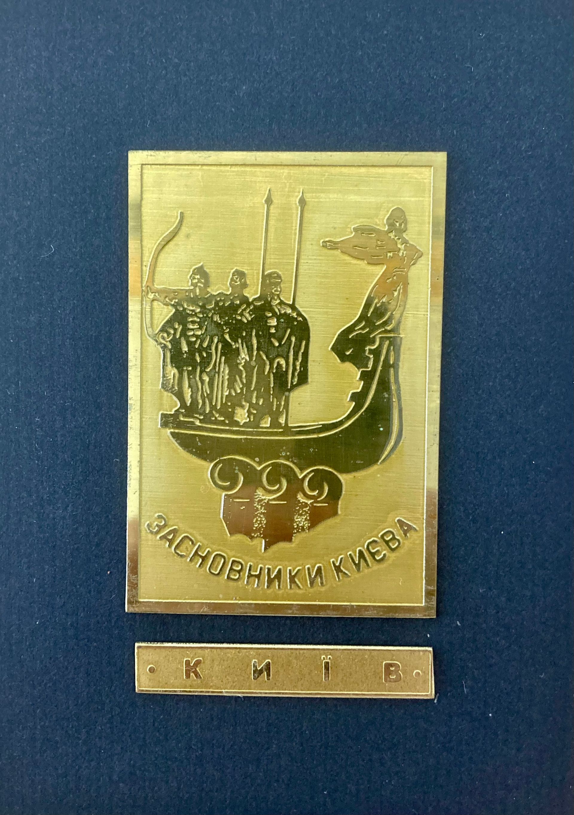 Eine goldene Plakette mit einem Bild eines Bootes und Soldaten darauf