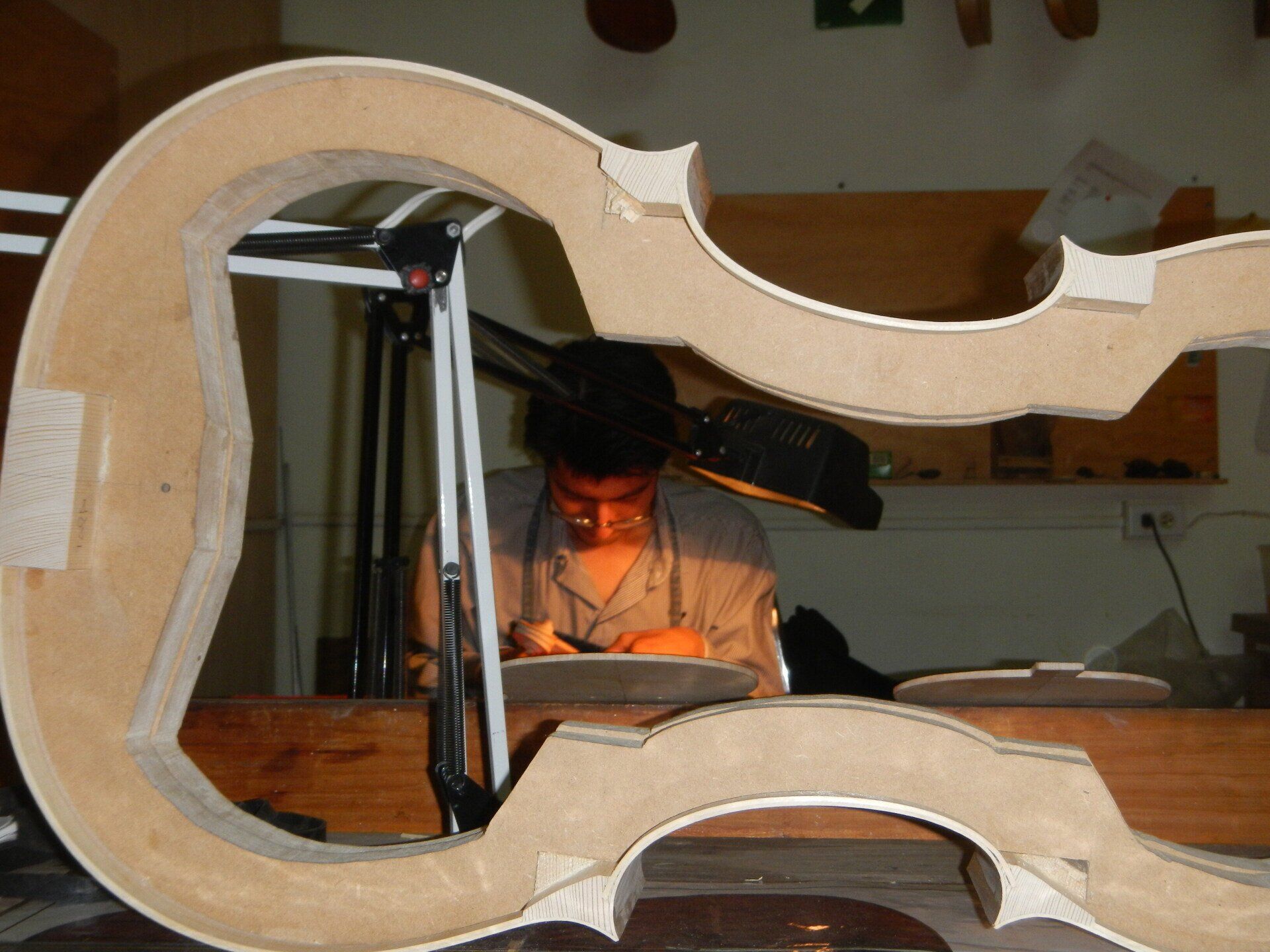 Ein Mann arbeitet in einer Werkstatt an einem Stück Holz