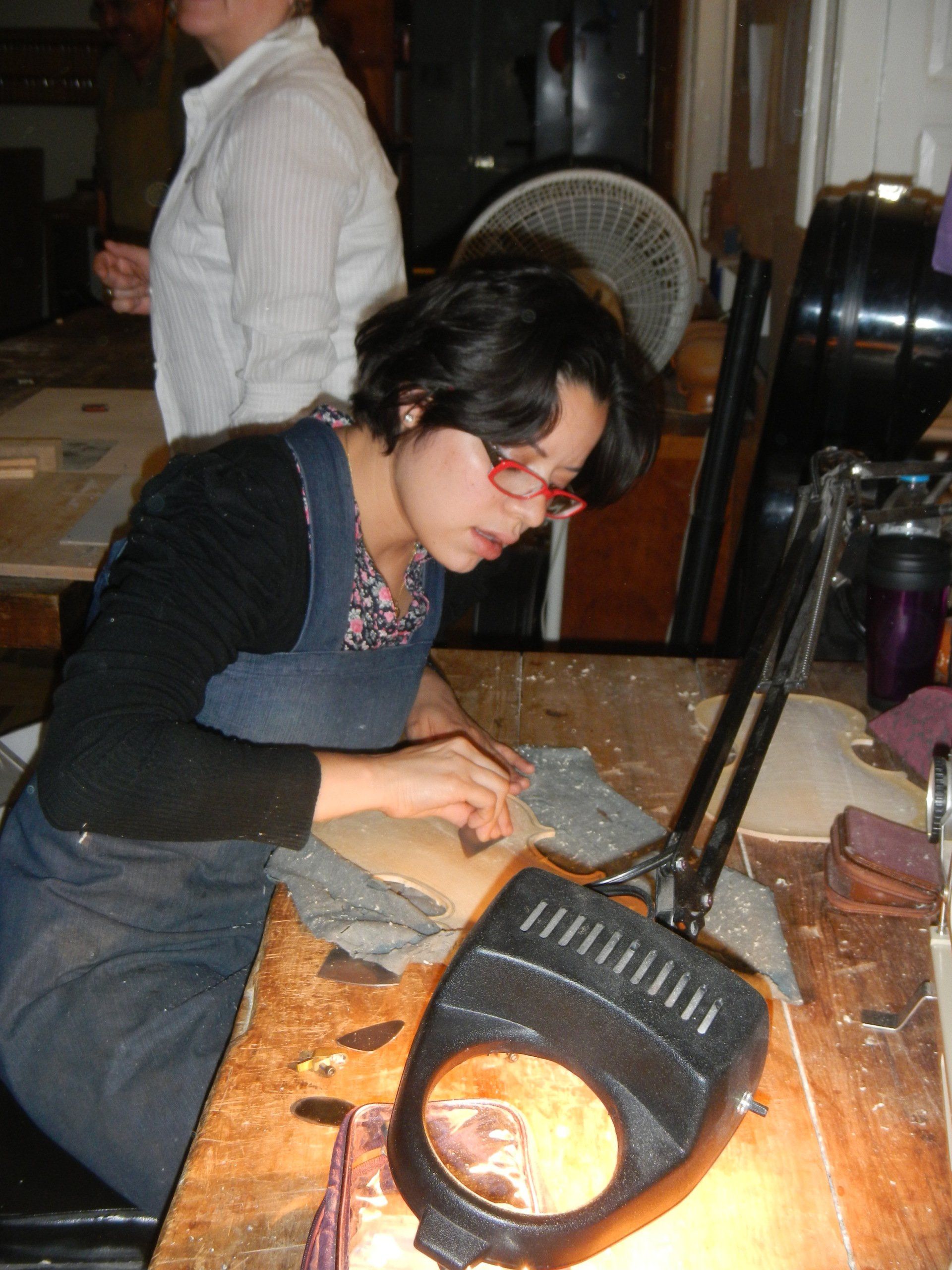 Eine Frau sitzt an einem Tisch mit einer Lupe darauf