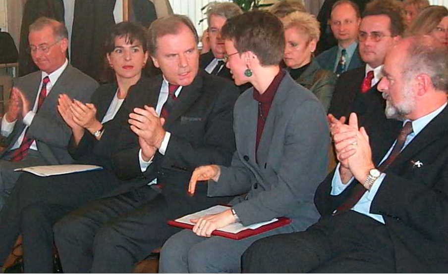 Eine Gruppe von Menschen in Anzug und Krawatte klatscht