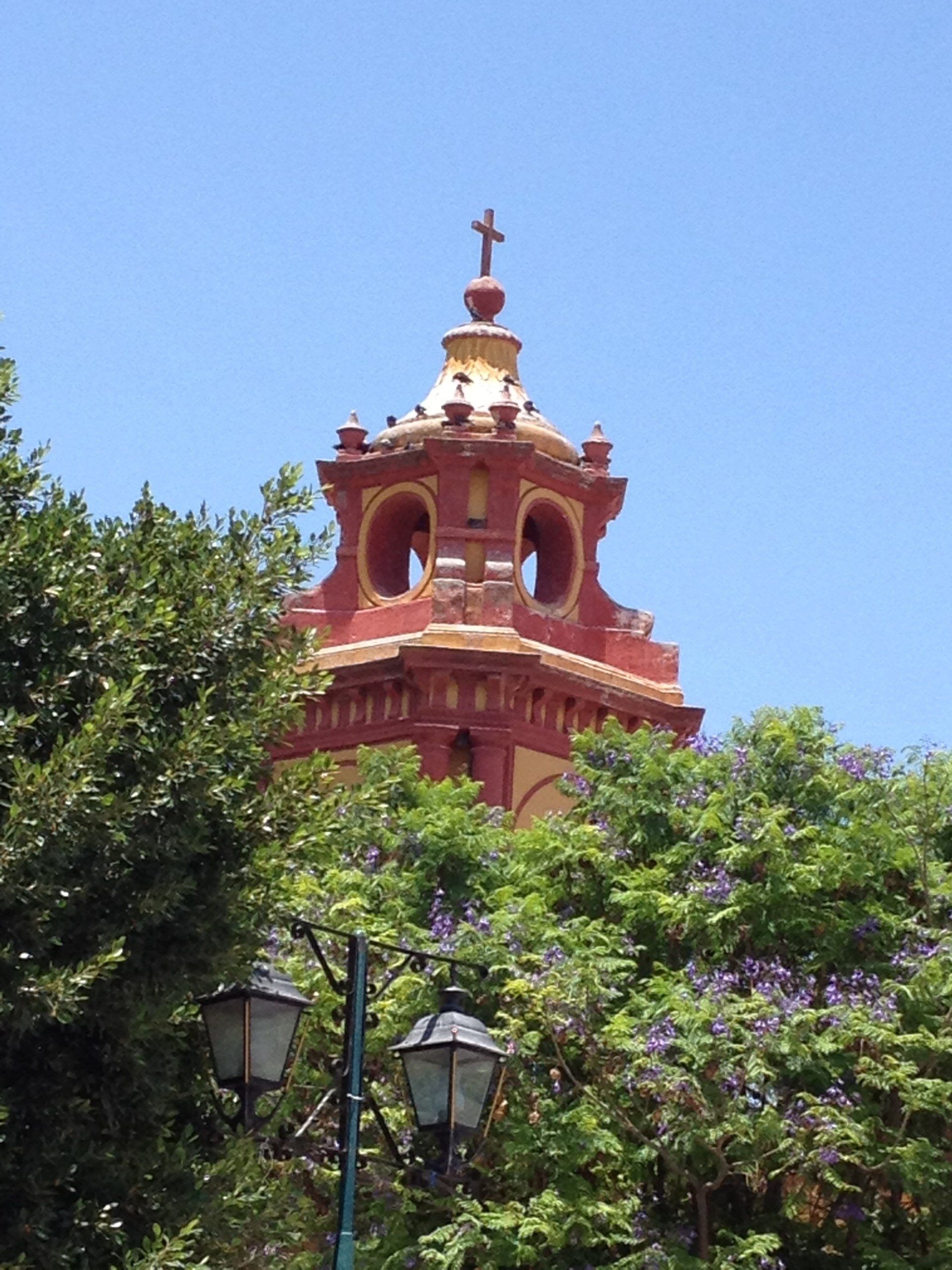 Ein Kirchturm mit einem Kreuz darauf
