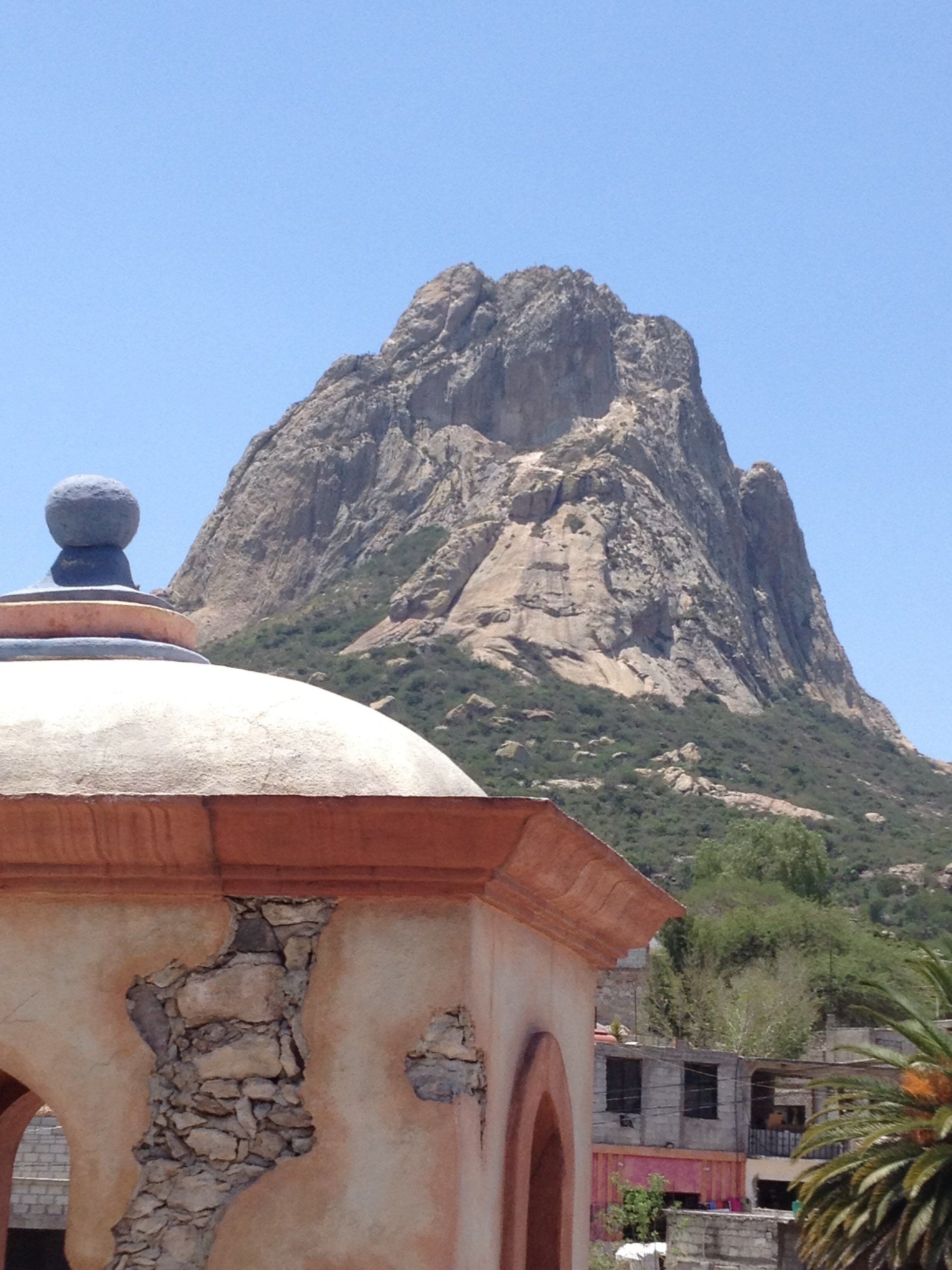 Ein Gebäude mit einer Kuppel darauf und einem Berg im Hintergrund