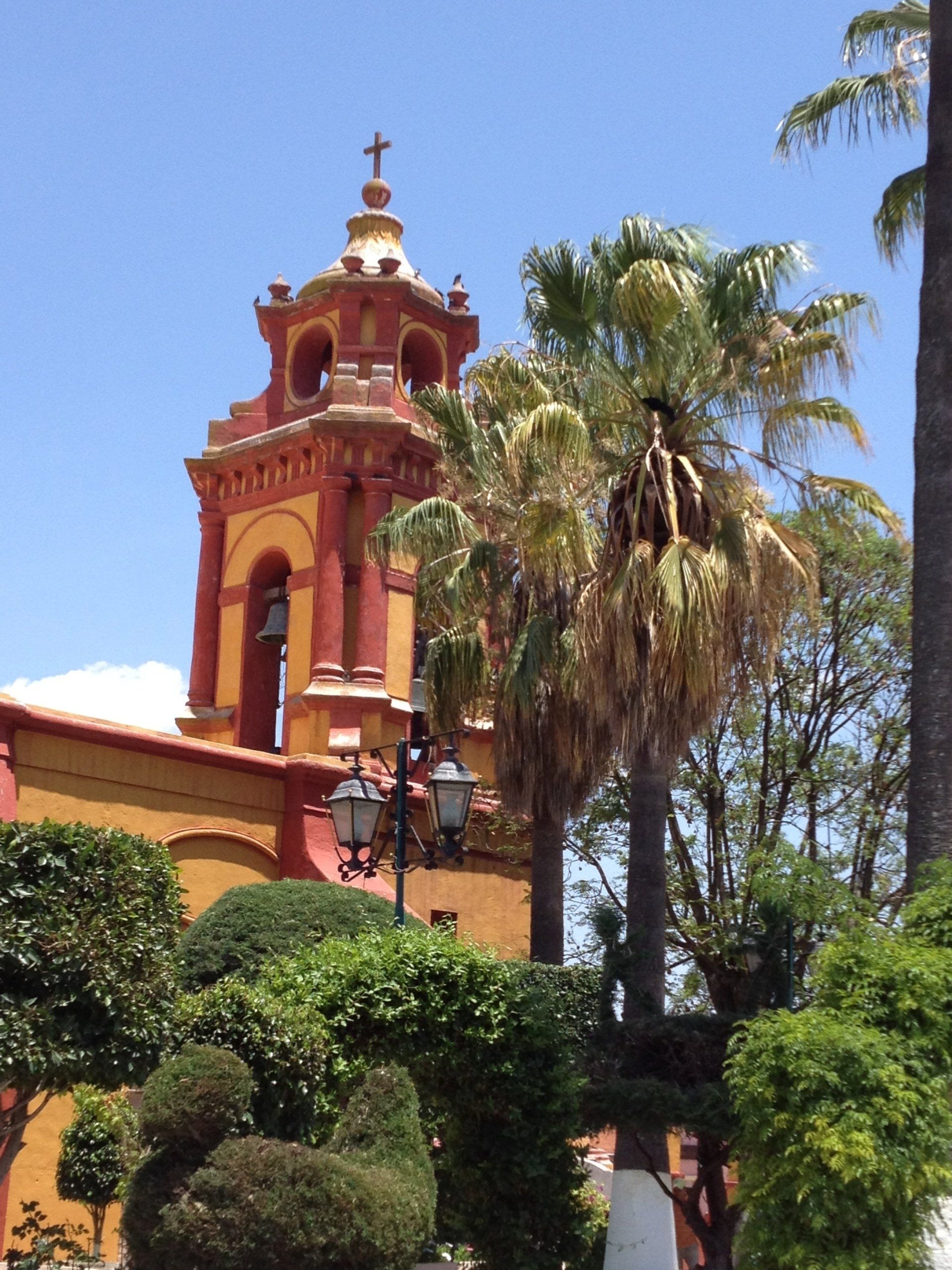 Eine Kirche mit einem Glockenturm, umgeben von Palmen
