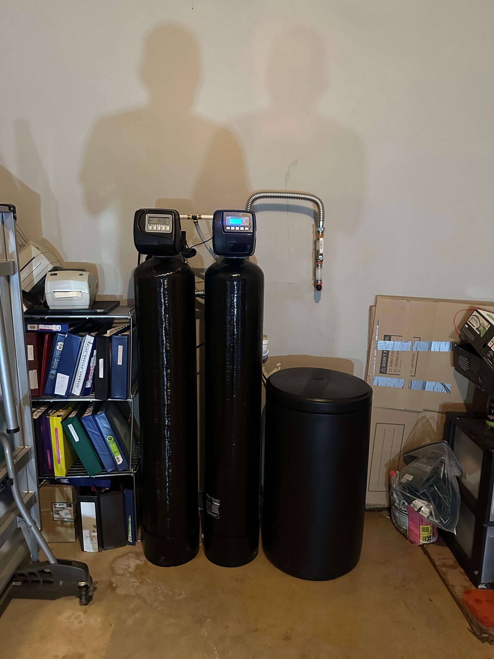Water filtration system with three black tanks and silver piping.