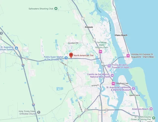 Map screenshot of a coastal city area with roads, waterways, and a red location pin.