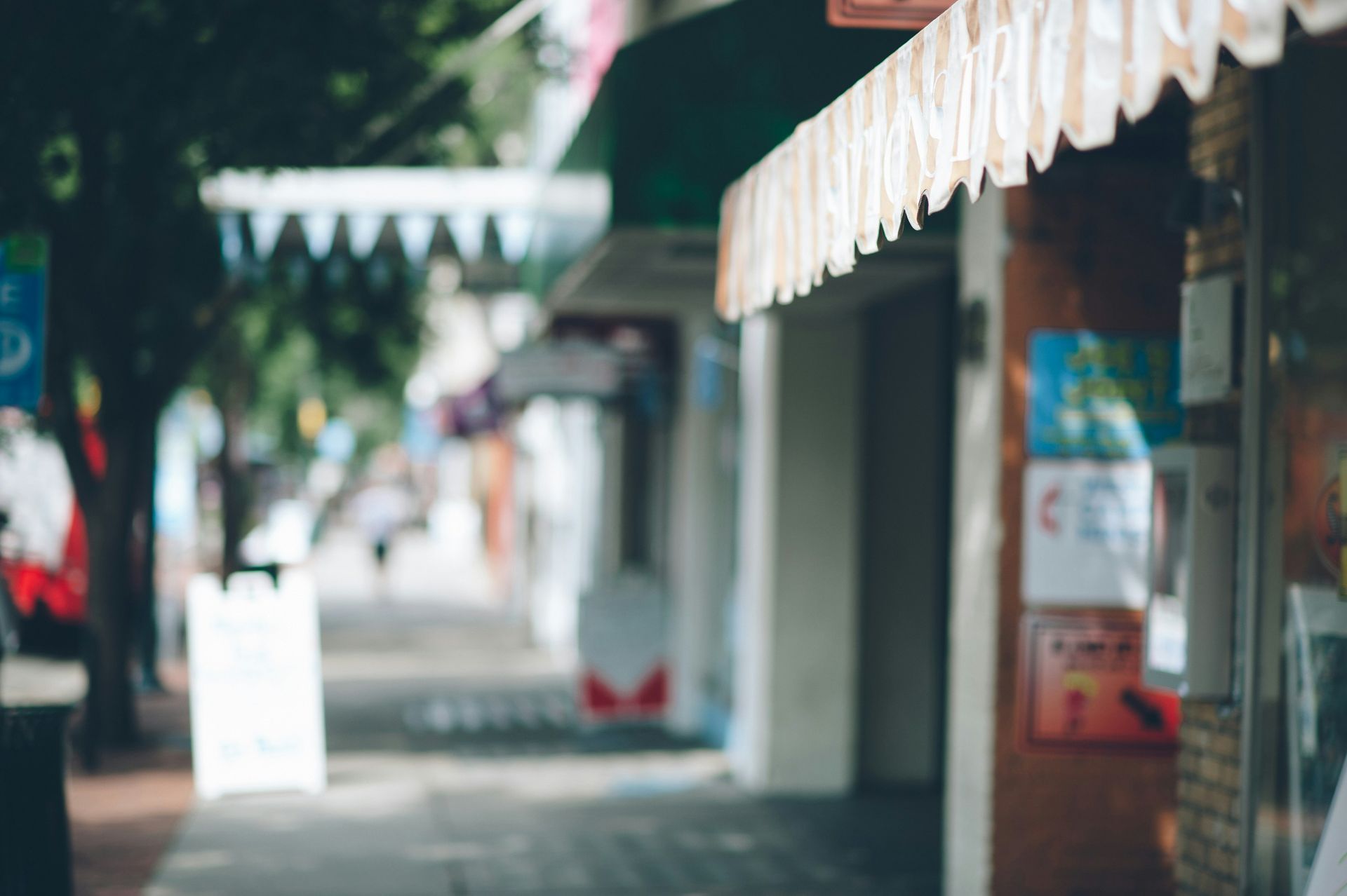 A row of stores on a city street with a green awning.