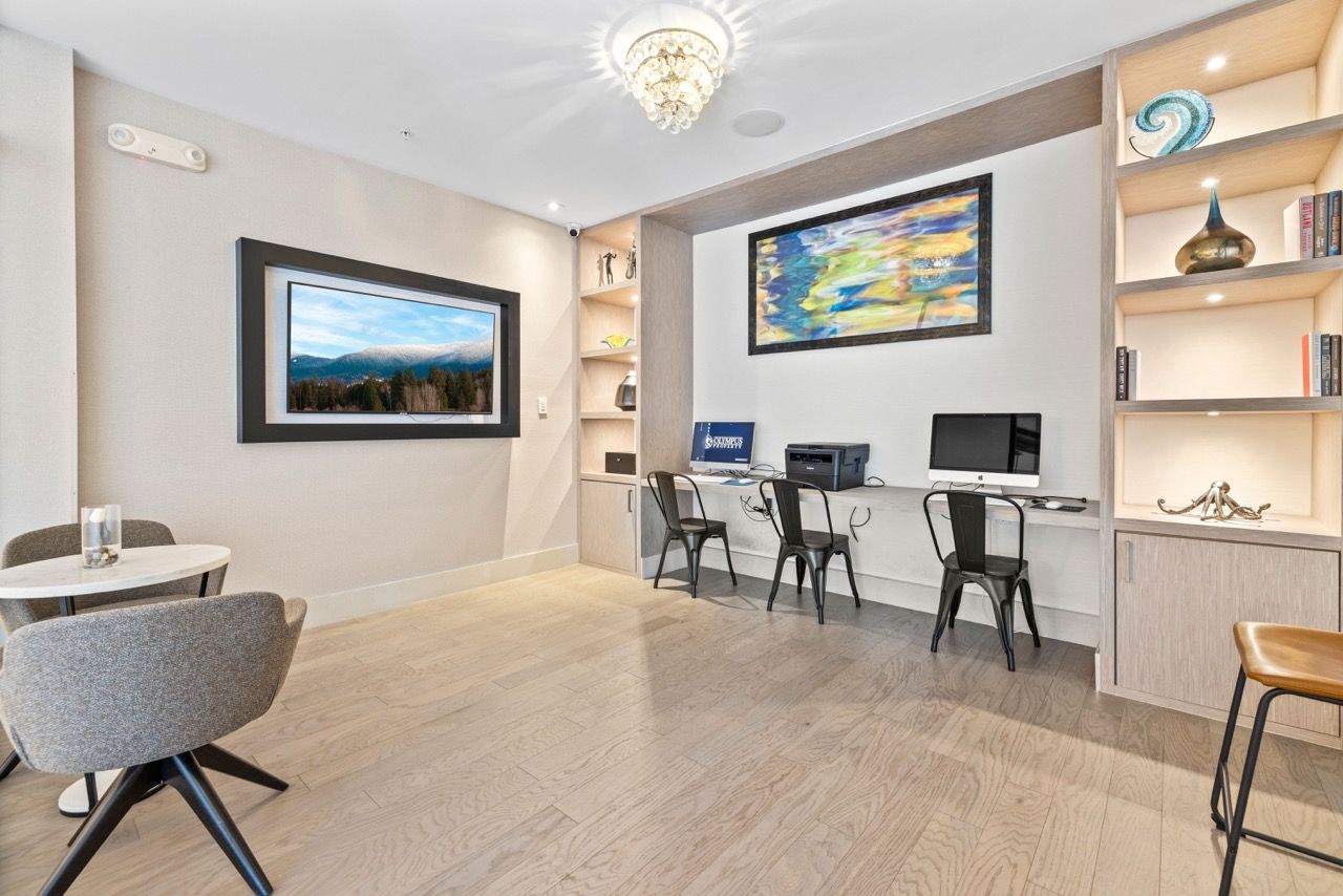 Modern communal work area with computer stations, built-in counter, and shelving.