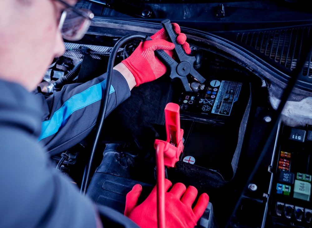 A Man In Red Gloves Is Working On A Car Battery — Auto Elect In Parramatta Park, QLD